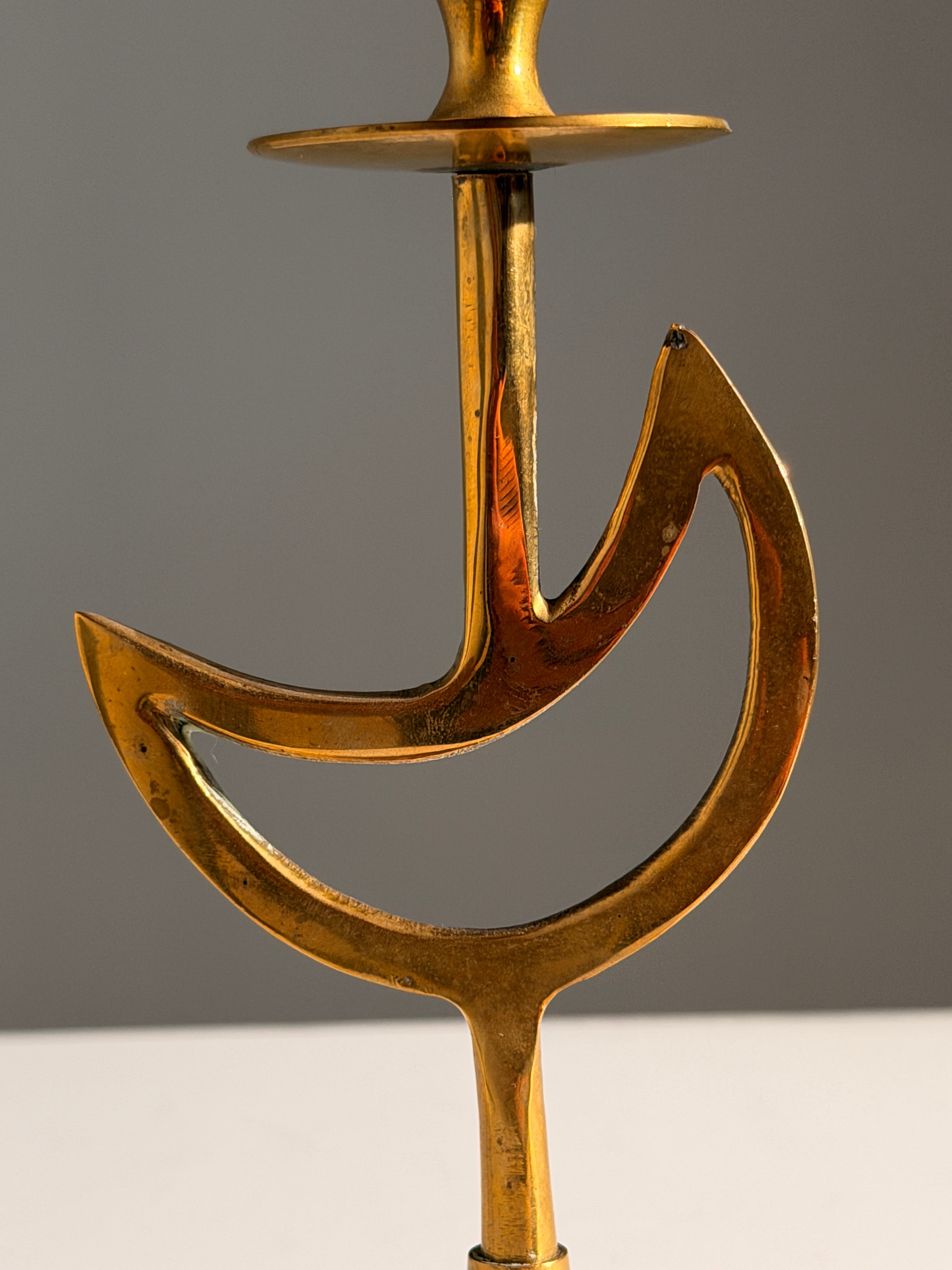 Pair of brass candlesticks with a crescent-moon motif, France, circa 1970 — side angle