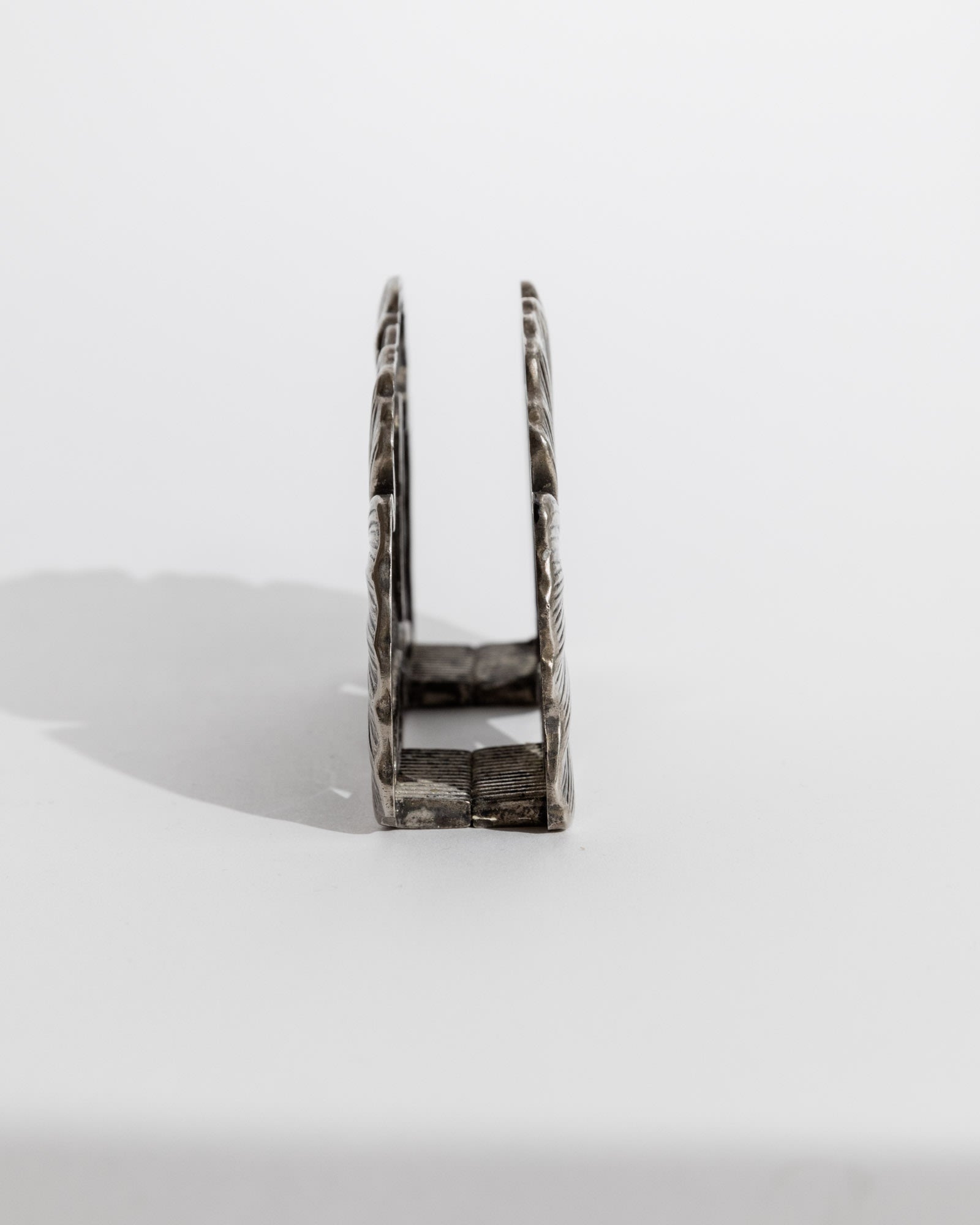 Side profile view of 1960s silver plated desk holder with ornate detailing