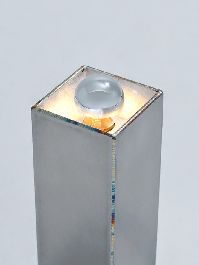 Objects of Function No. 2603 — close-up of polished metal lamp with glass orb