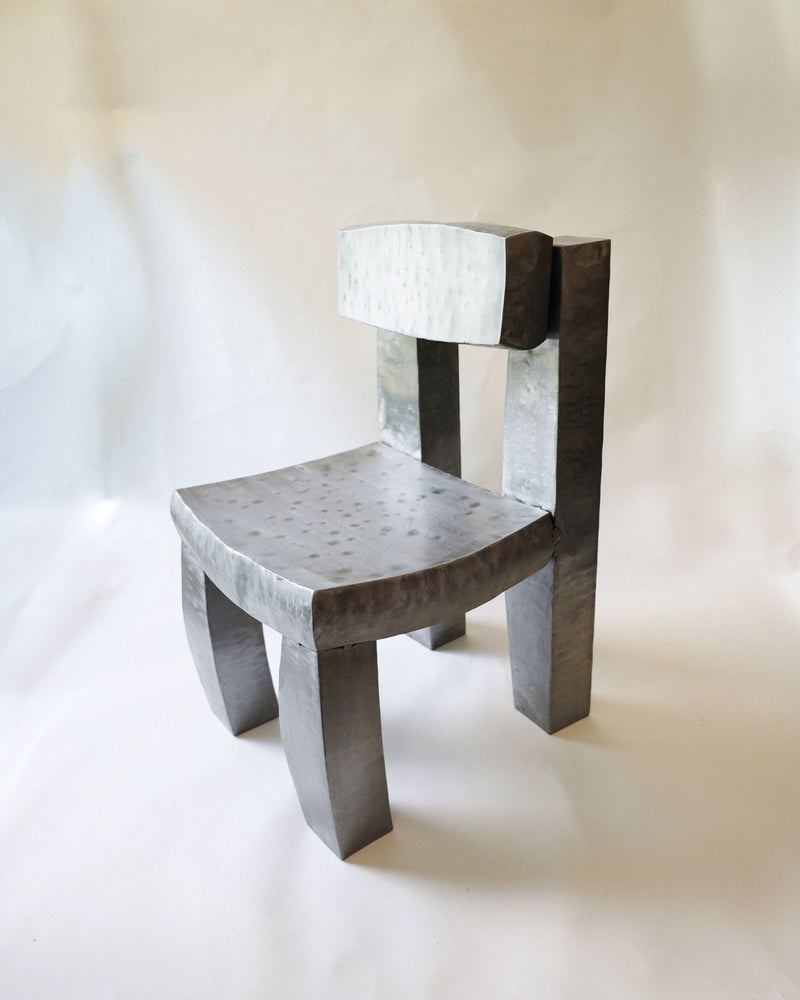 Gray concrete Joe chair with geometric backrest and textured seat by Jesse Butterfield