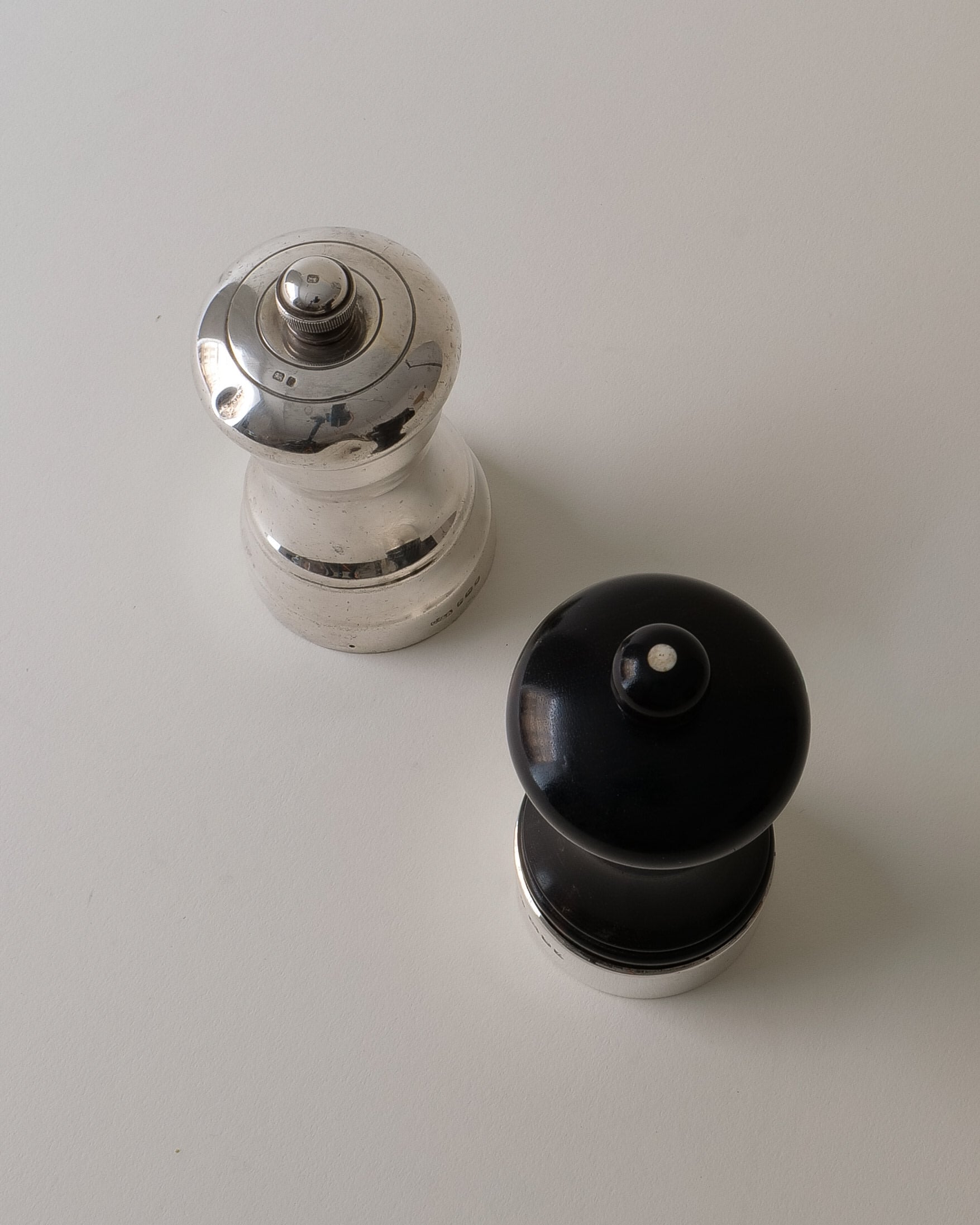 Disassembled English silver salt and pepper grinders showing mechanism