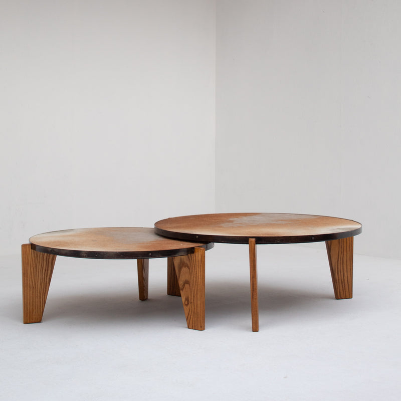 2 Coffee Tables in Wood and Cowhide — close-up of round tops and wooden legs