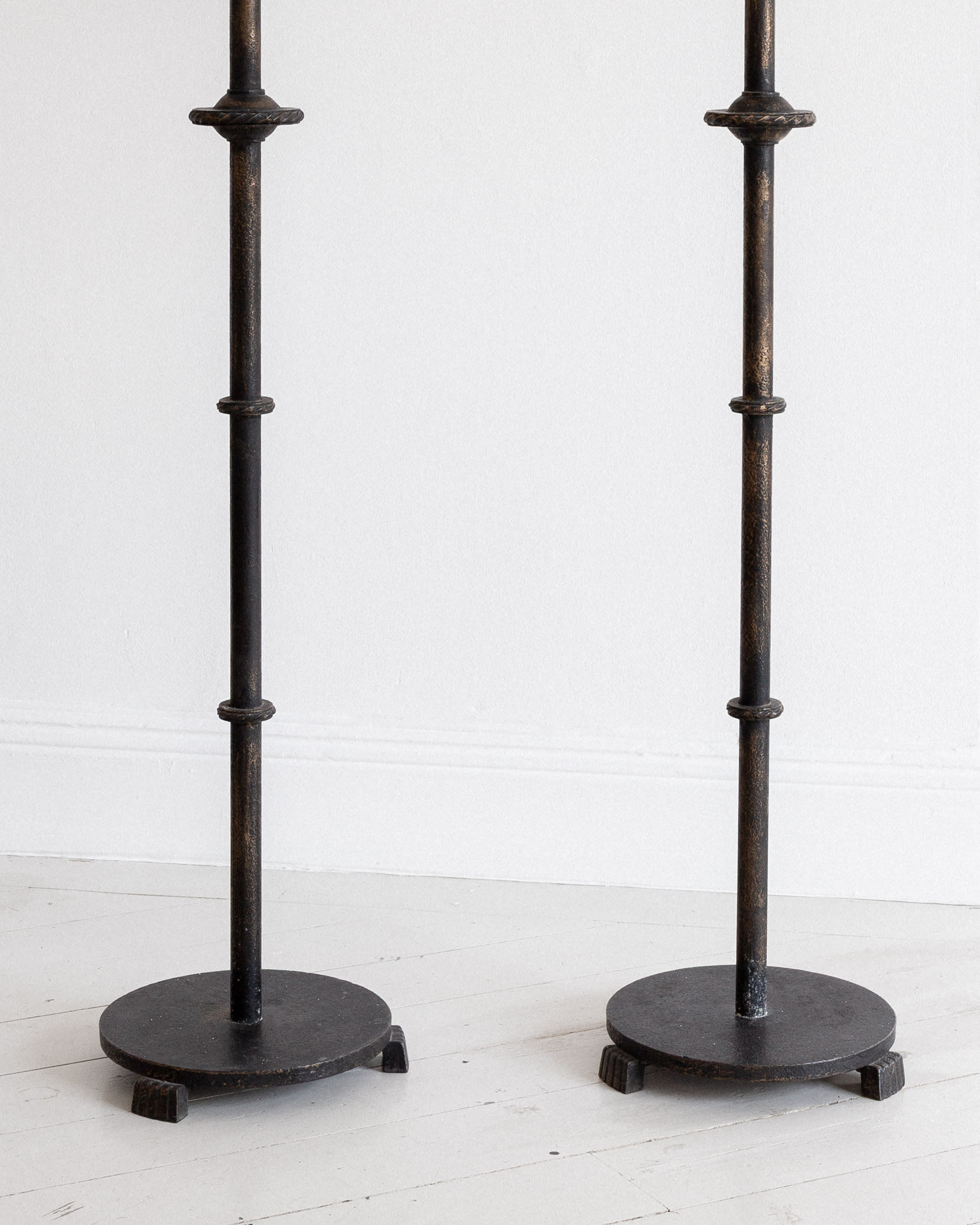 Pair of Monumental Cast Iron Floor Candleholders by Böhlmarks, Sweden, 1930s — front view on white wooden floor