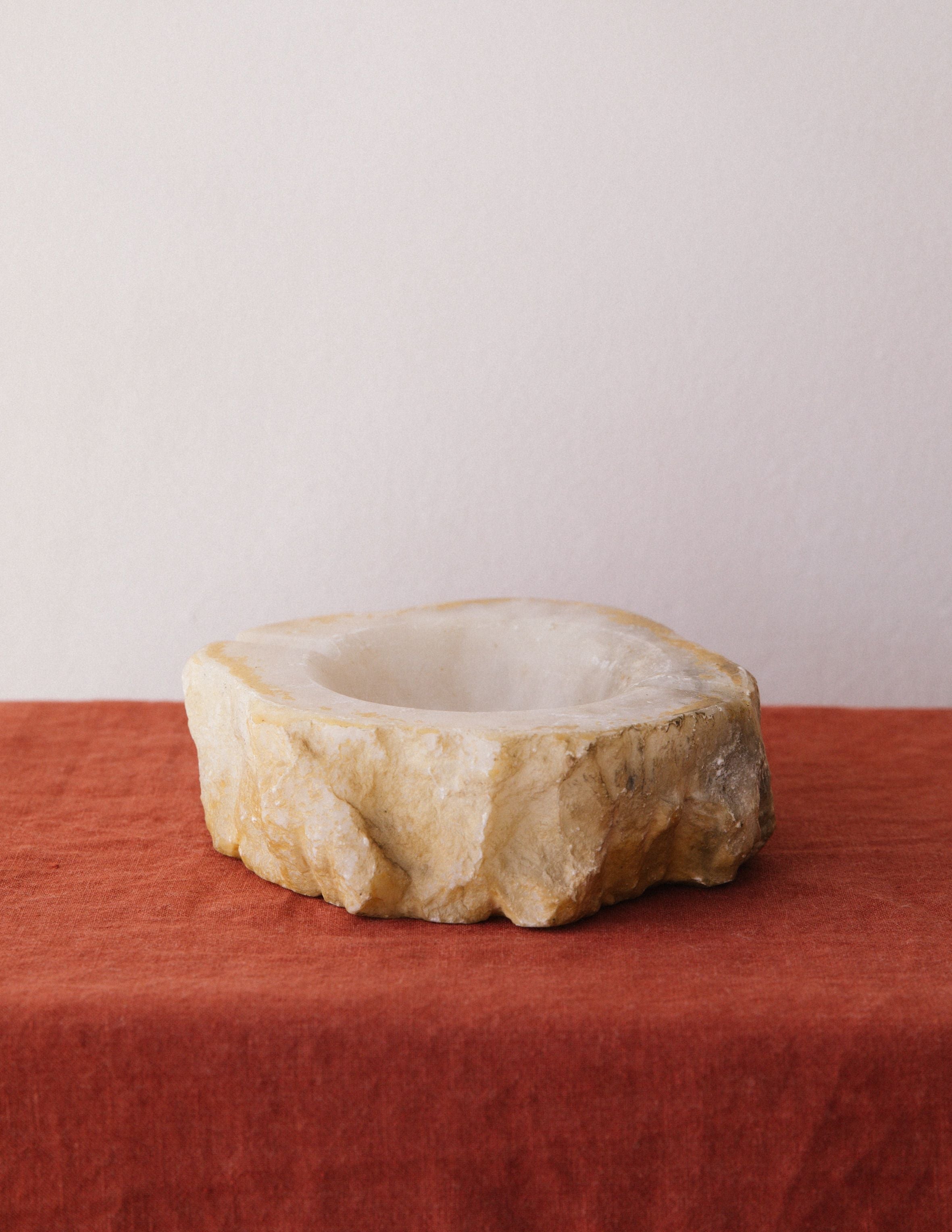 Round alabaster ashtray with natural stone texture and carved bowl