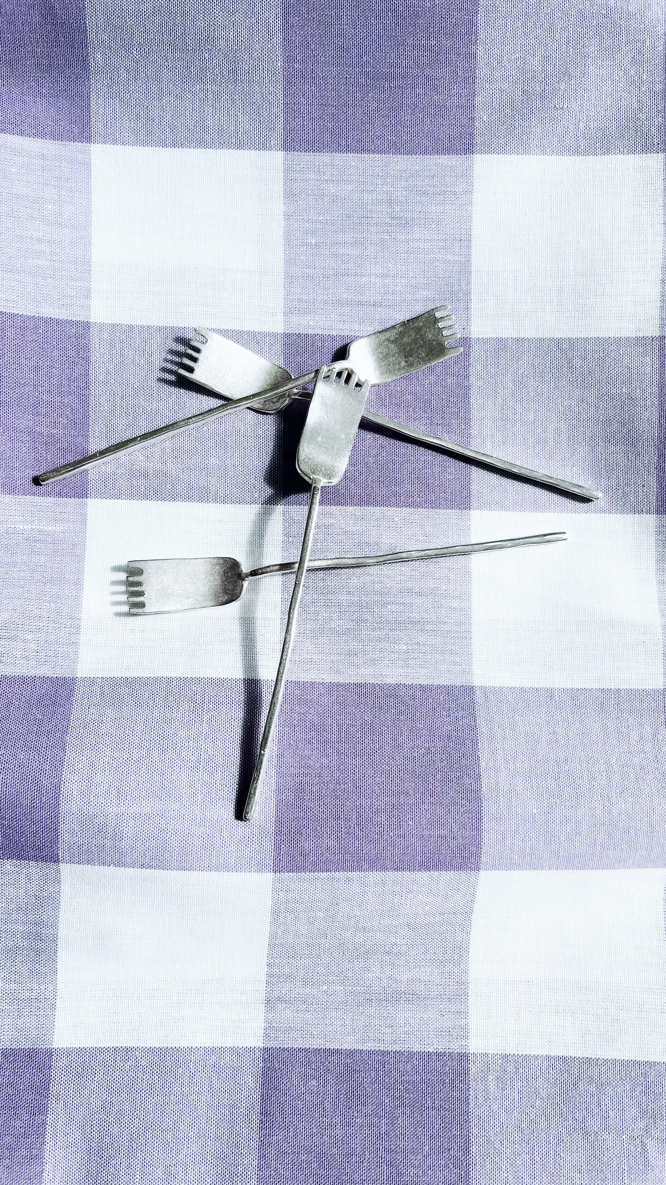 Artifact tea cutlery duo crossed arrangement on checkered cloth