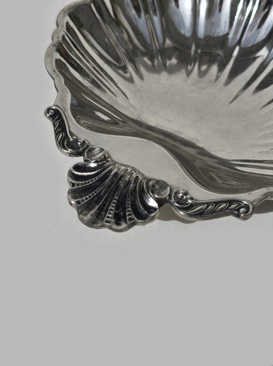 A set of 4 small shell vide-poches by Les Objoies, featuring ornate silver-plating and decorative handles in a scallop shell design, displayed against a plain gray background.
