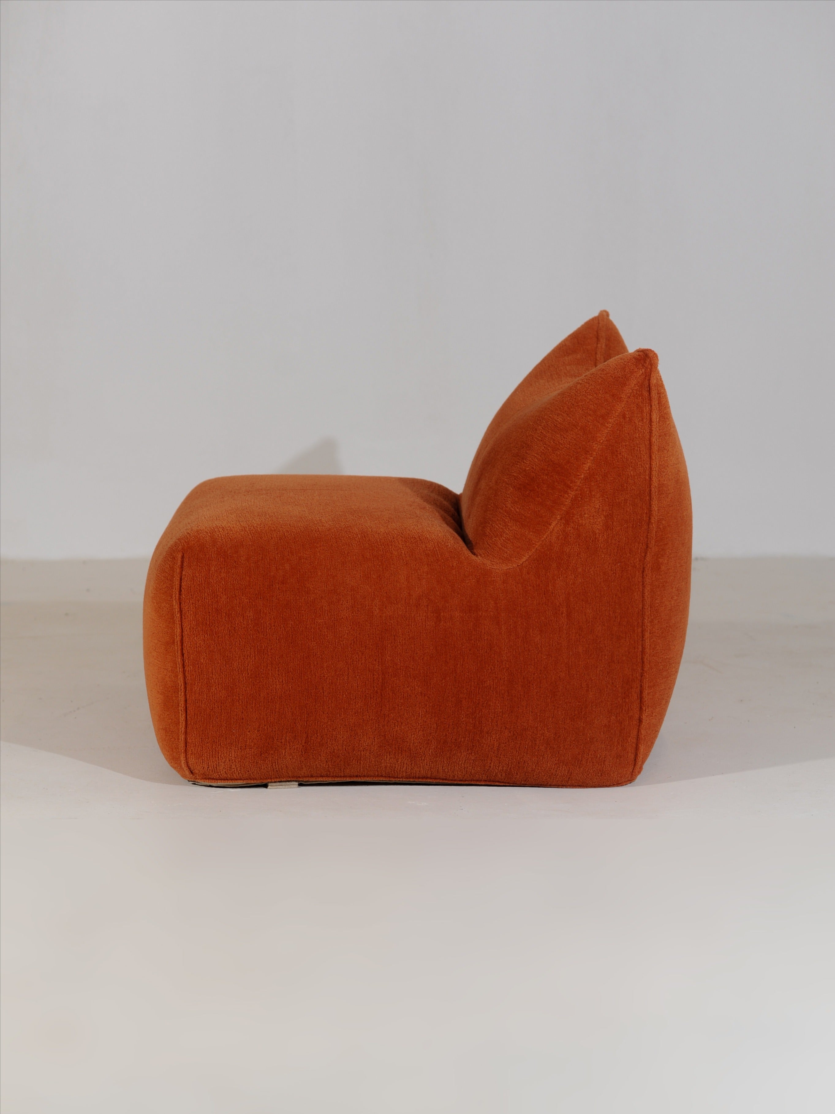 Orange Le Bambole armchair profile view showing curved silhouette