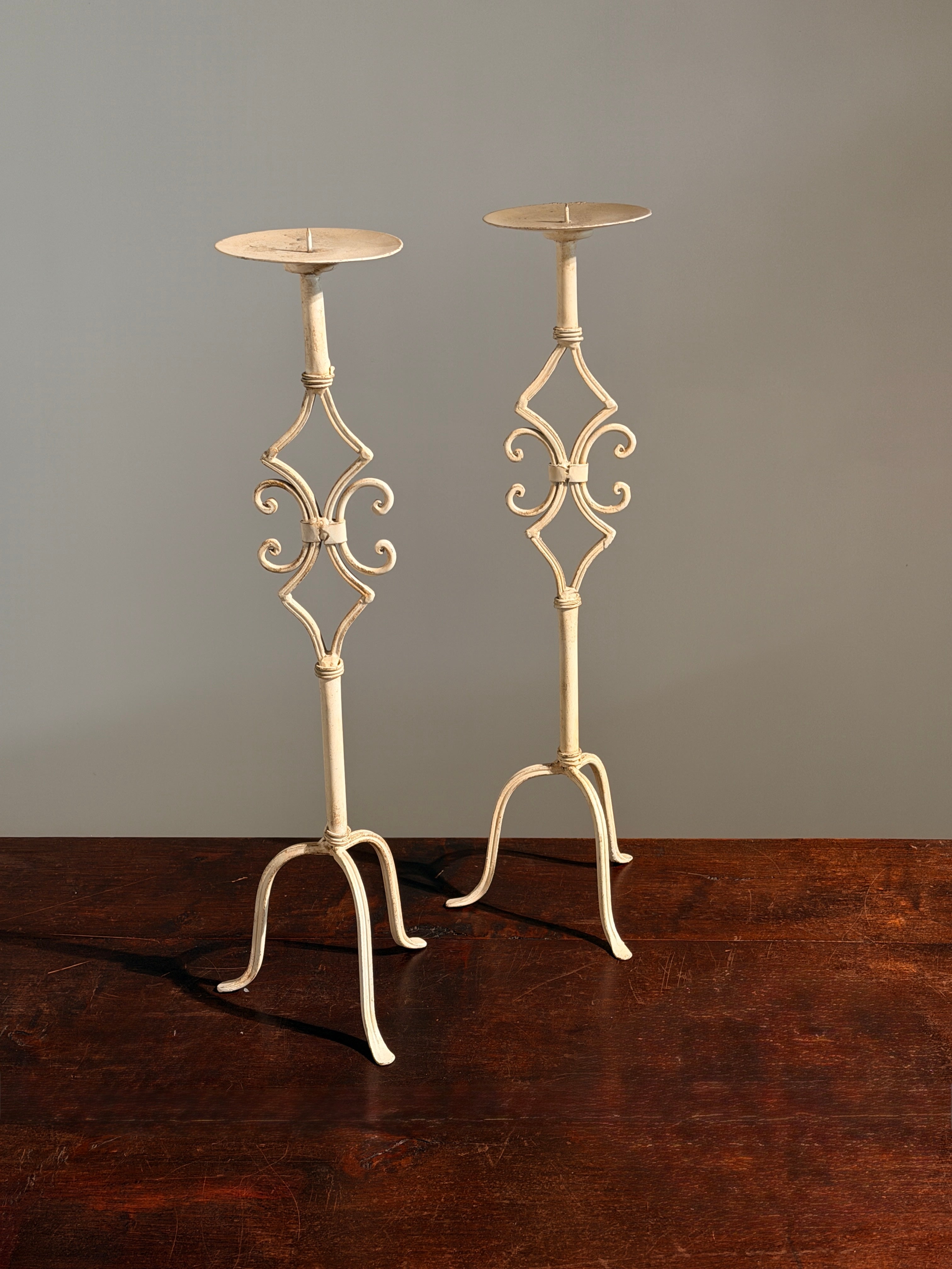 Pair of large cream-painted wrought-iron pricket candlesticks, Italy — side angle