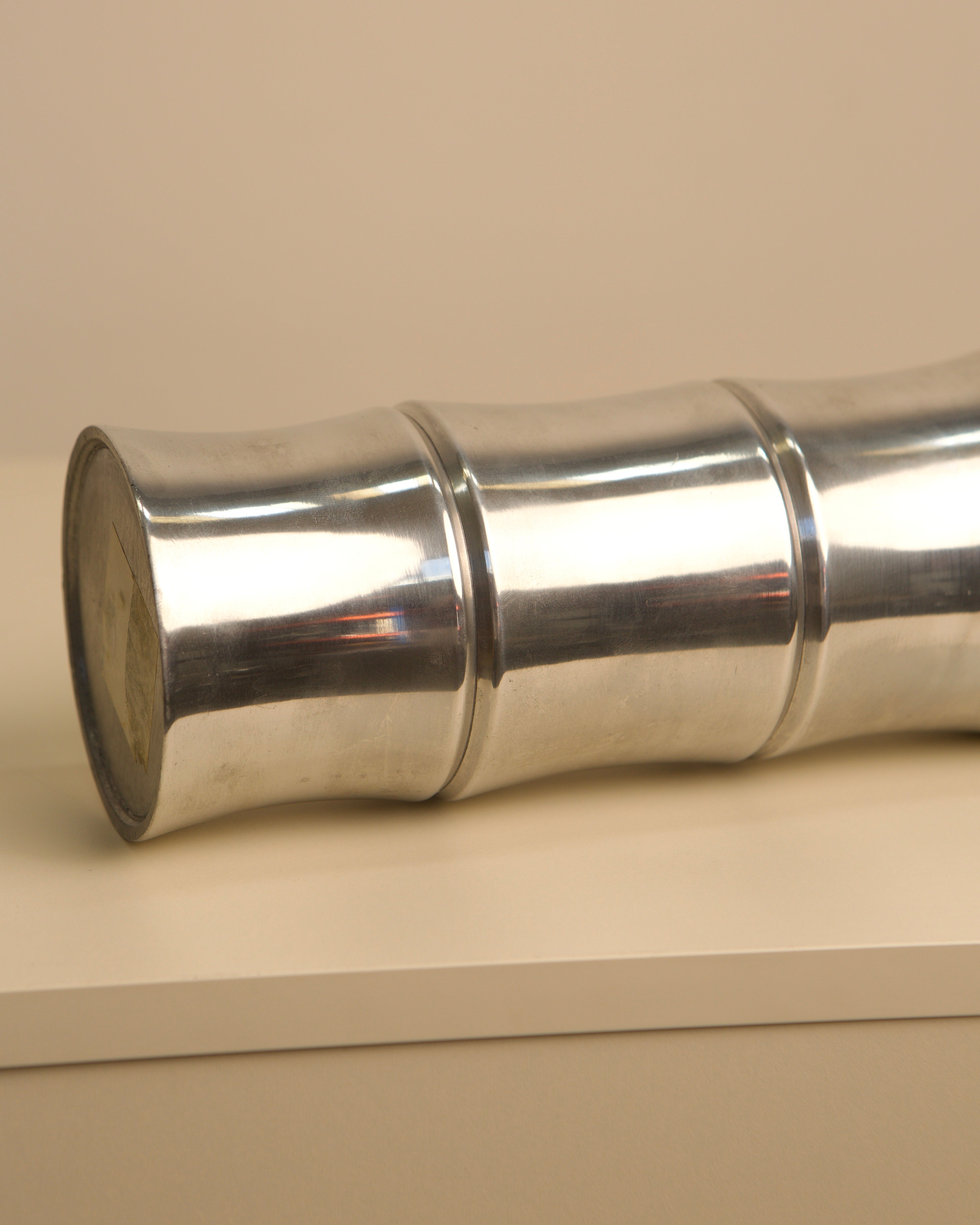 Polished aluminum cylindrical vase showing curved profile detail