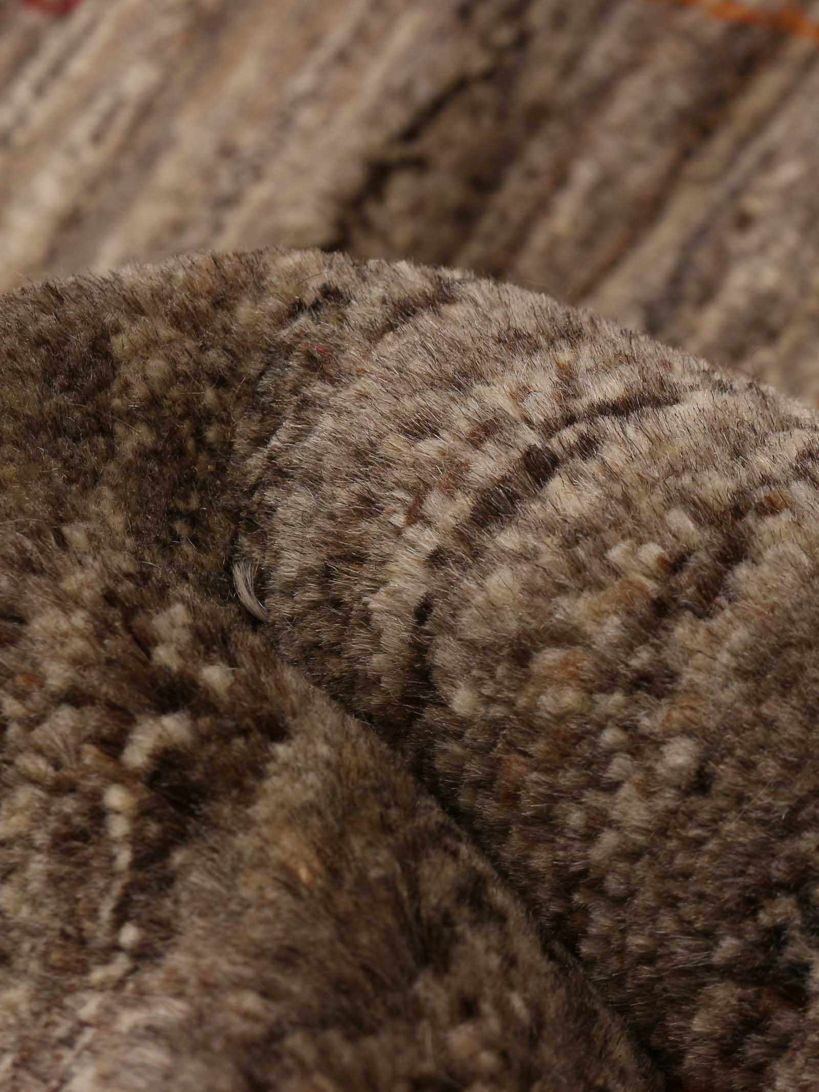 A close-up of the Gabbeh Rug in Sable by catalog:three, featuring fluffy, textured brown fur fabric with varying shades and patterns, highlighting its cozy plush pile. Dimensions: 174 x 232 cm.