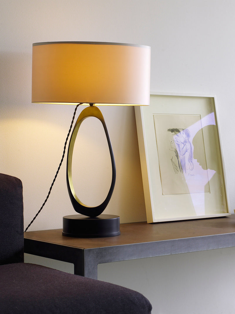 STELLA Table — close-up of black base with brass accent