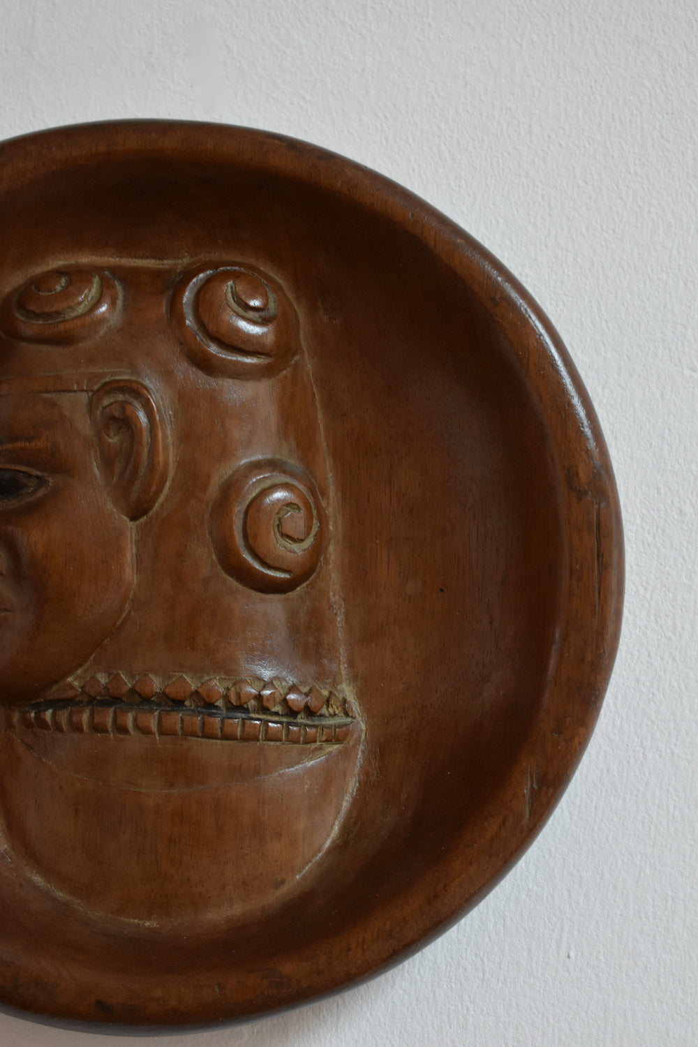 Africanist Low Relief Round Wooden Wall Sculpture — close-up of carved wooden face detail