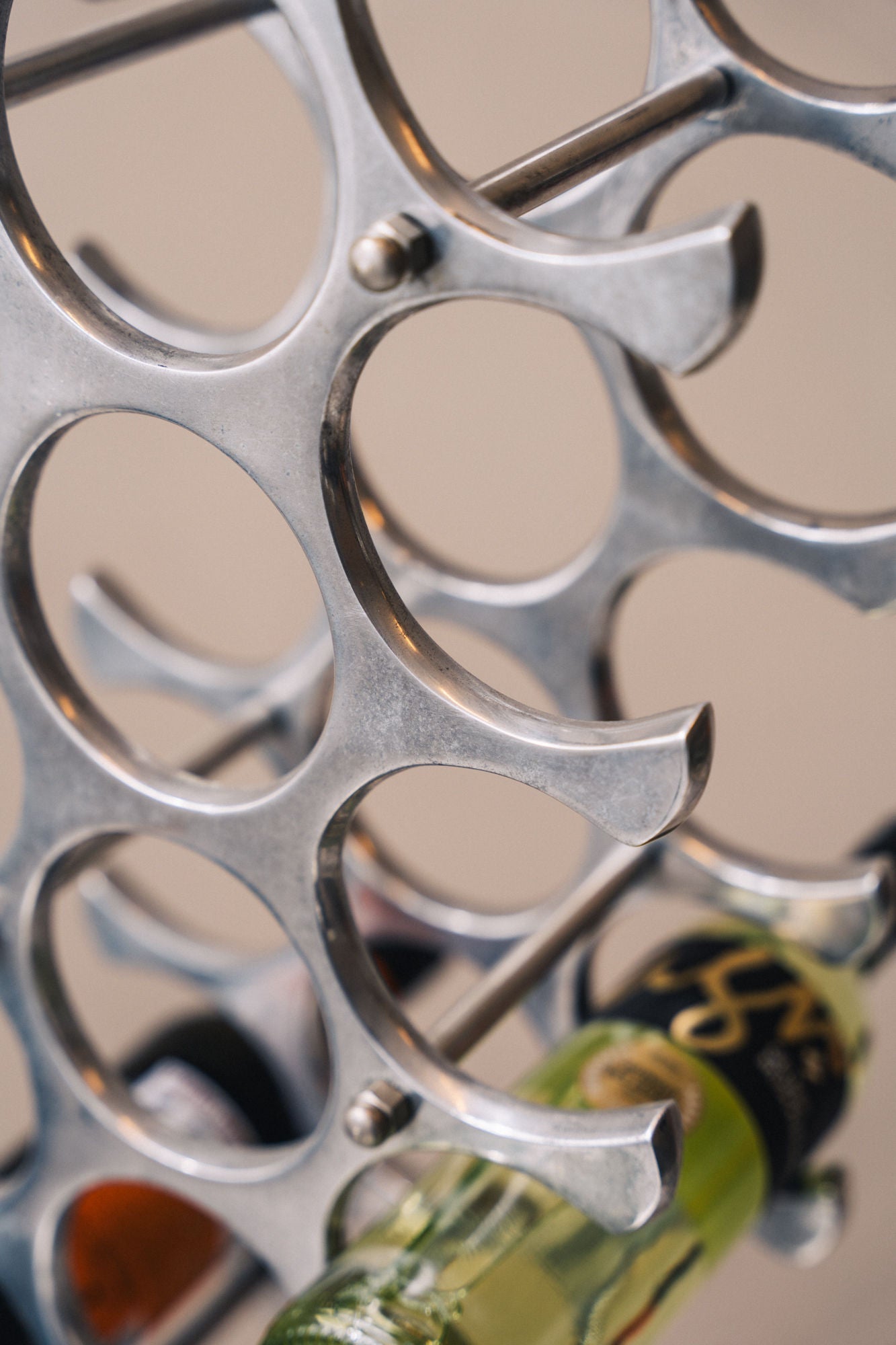 Polished aluminum wine rack with circular bottle holders detail
