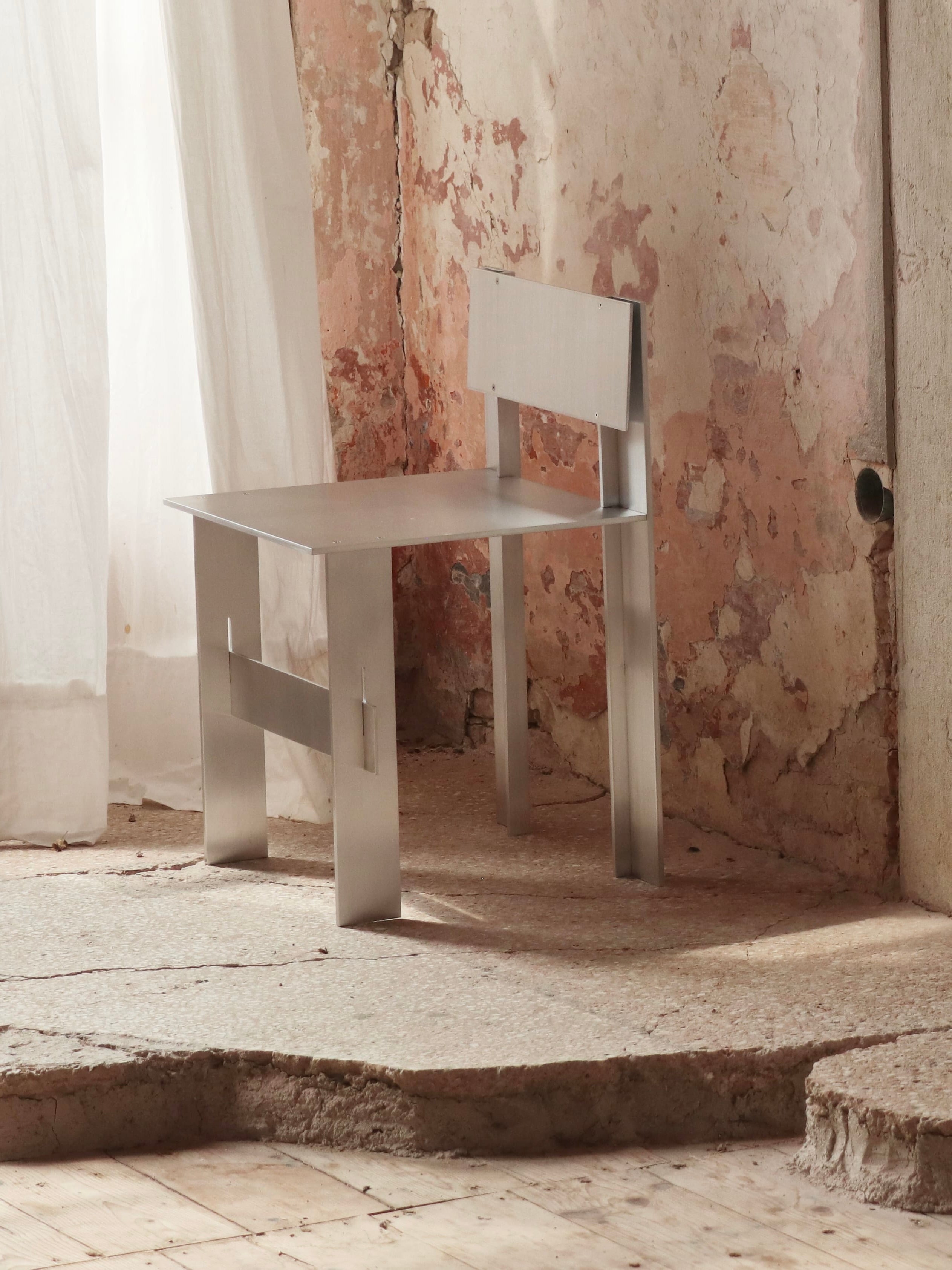 AL Chair — close-up of brushed aluminum surface in minimal setting