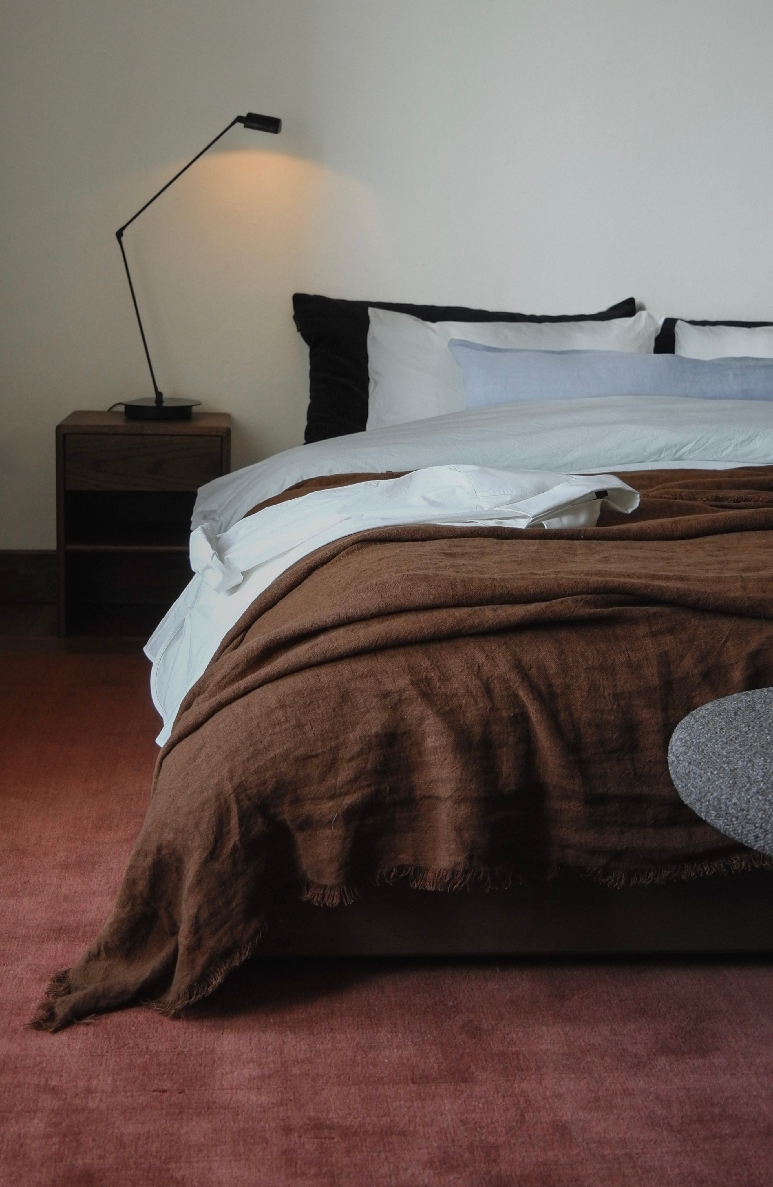 Hand-woven Rug in New Zealand Wool, Rouille — back view on bedroom floor
