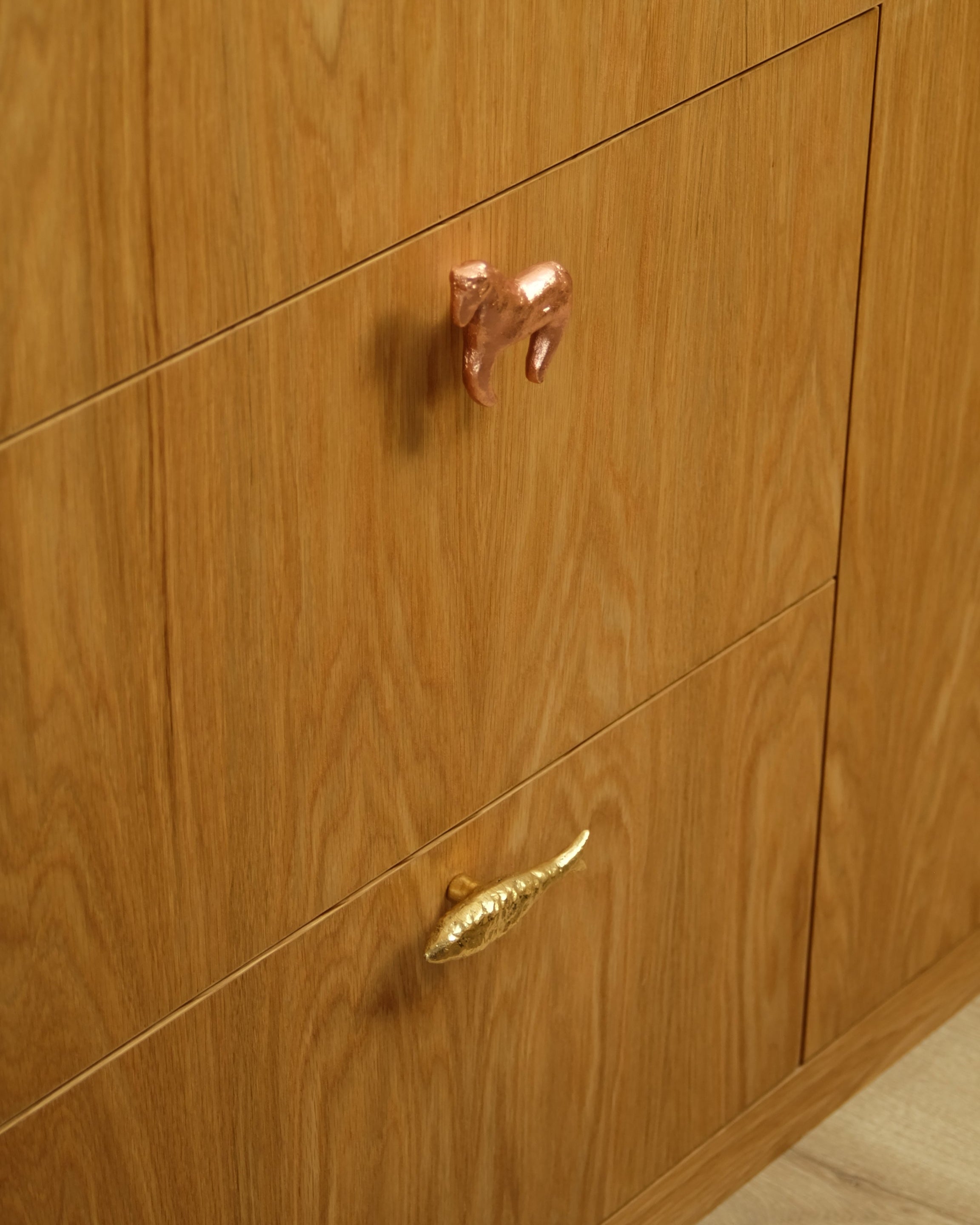 FISH Cabinet Knob/Wall Hook — installed on wooden cabinet drawers