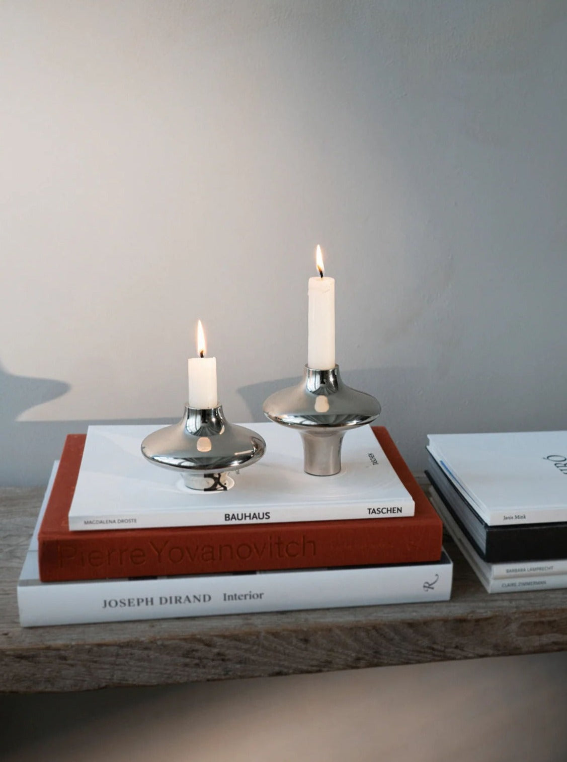 Doublet Candleholder - Large - Silver — positioned on stacked books with candlelight
