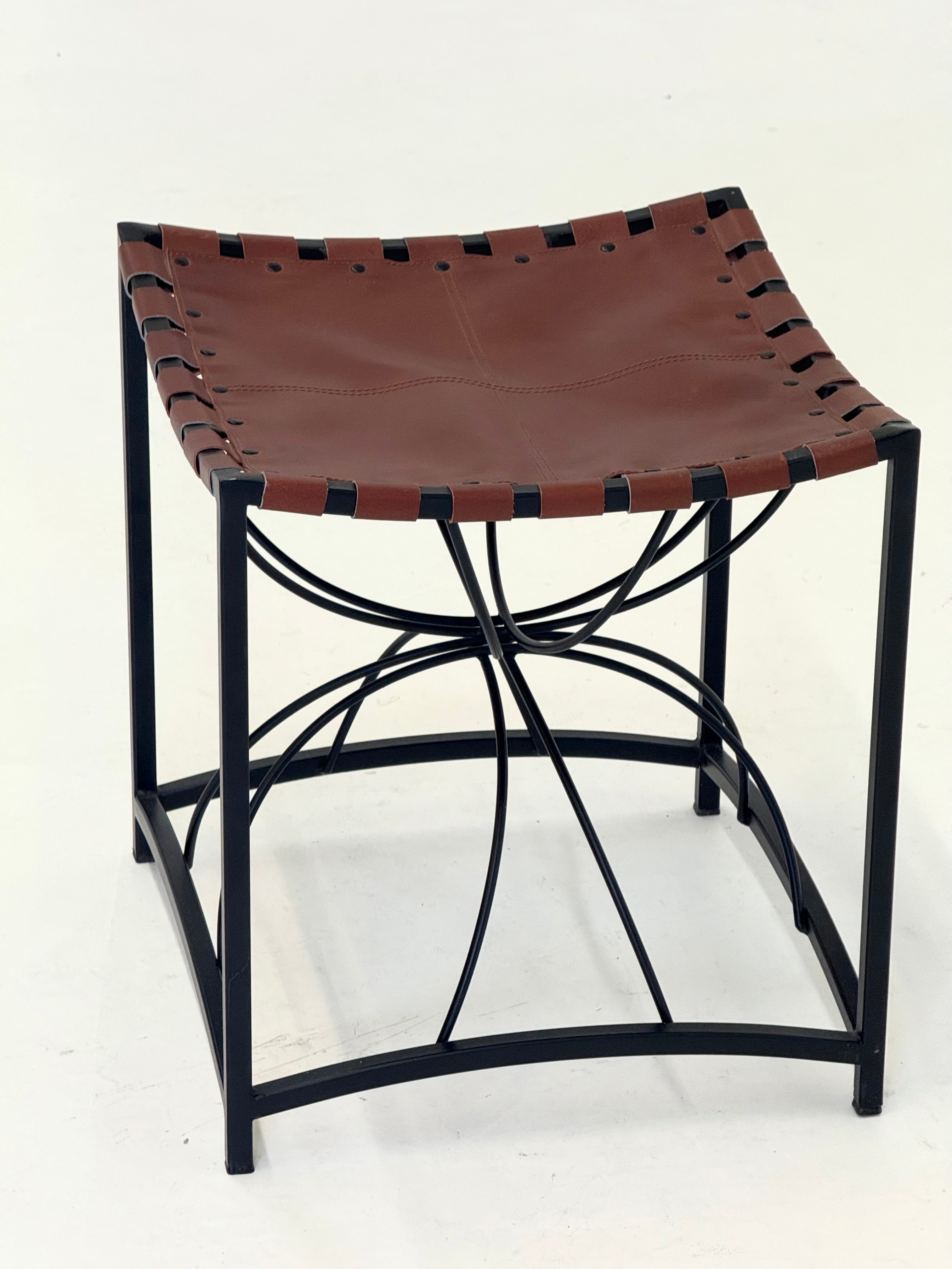 Elegant vintage French stool with black metal and brown leather — lifestyle setting