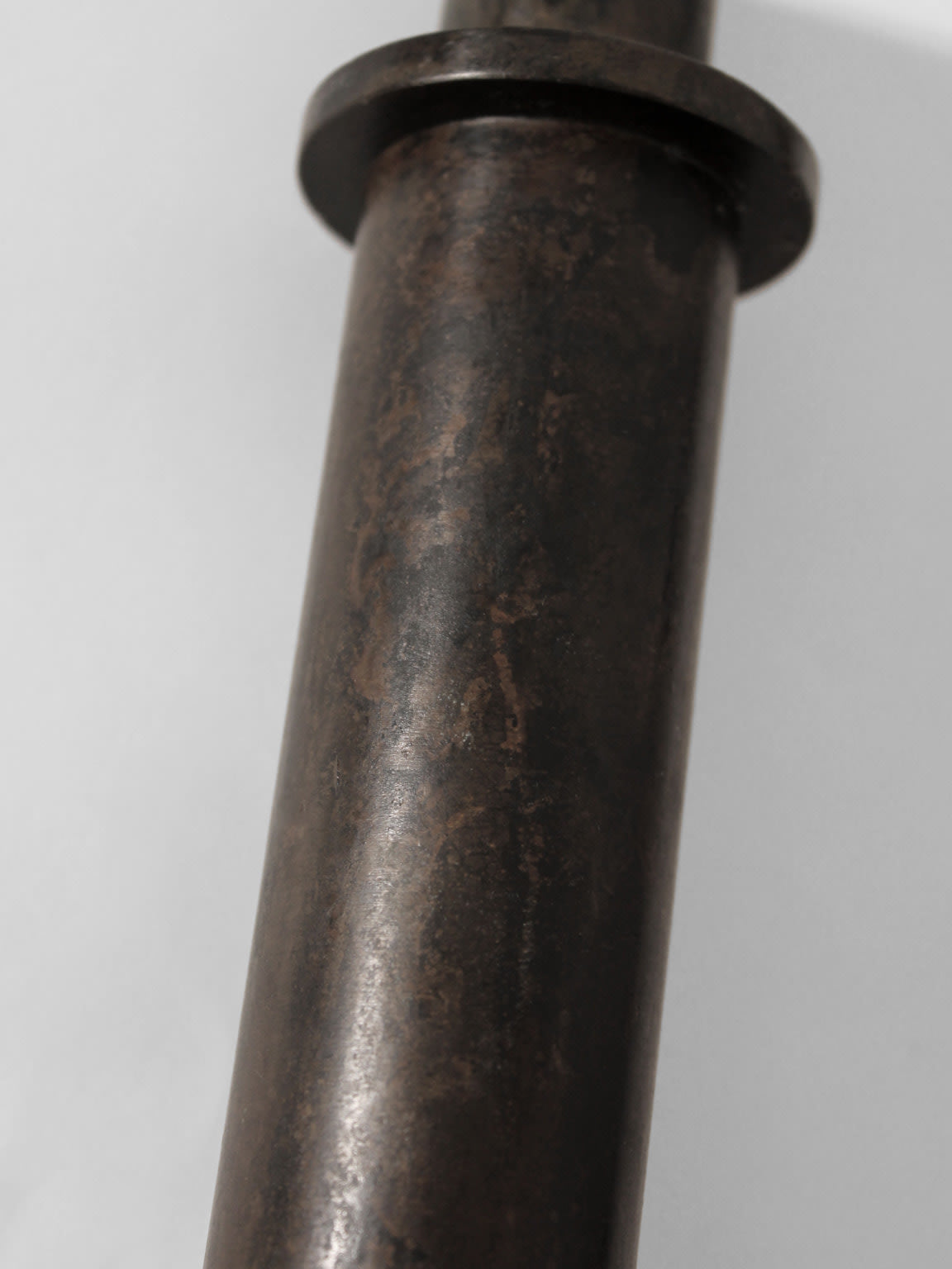A close-up of a Pair of Brutalist Massive Iron Candle Holders by Vintage Stories (1970s) shows their cylindrical, weathered metal with flanges, evoking vintage style against a plain light background.