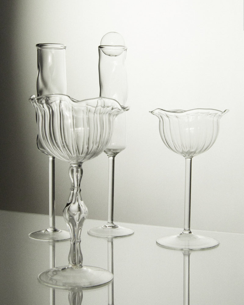 Clear glass champagne coupes with ribbed bowls in elegant arrangement