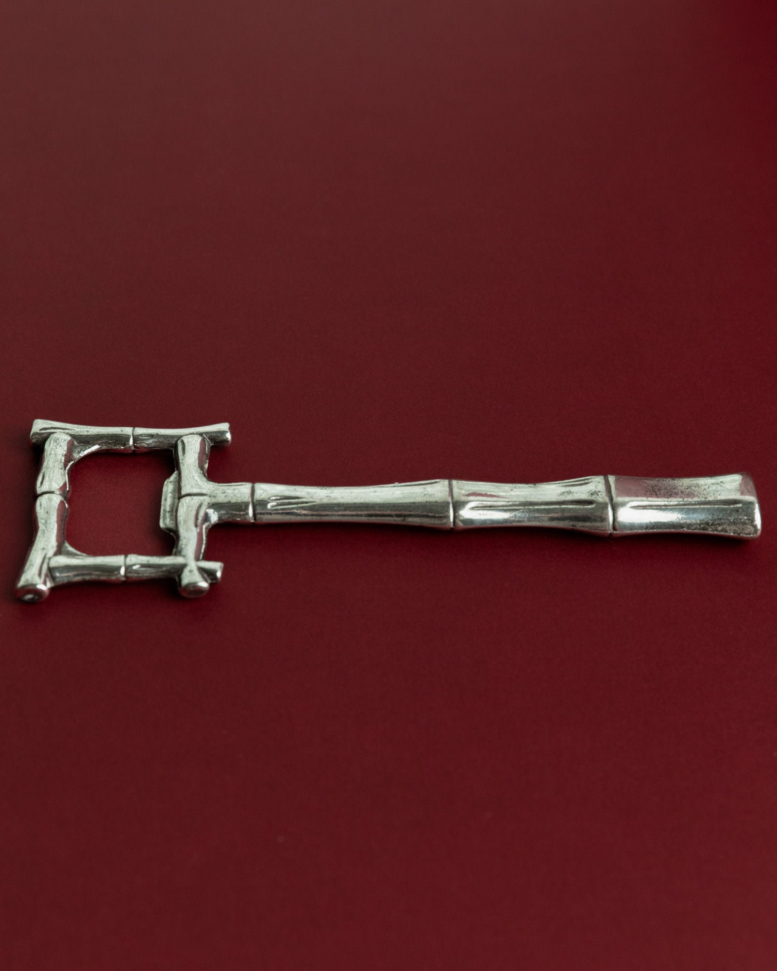 Vintage 1970s Silver Plated Bottle Opener, Bamboo Design — back view on red background