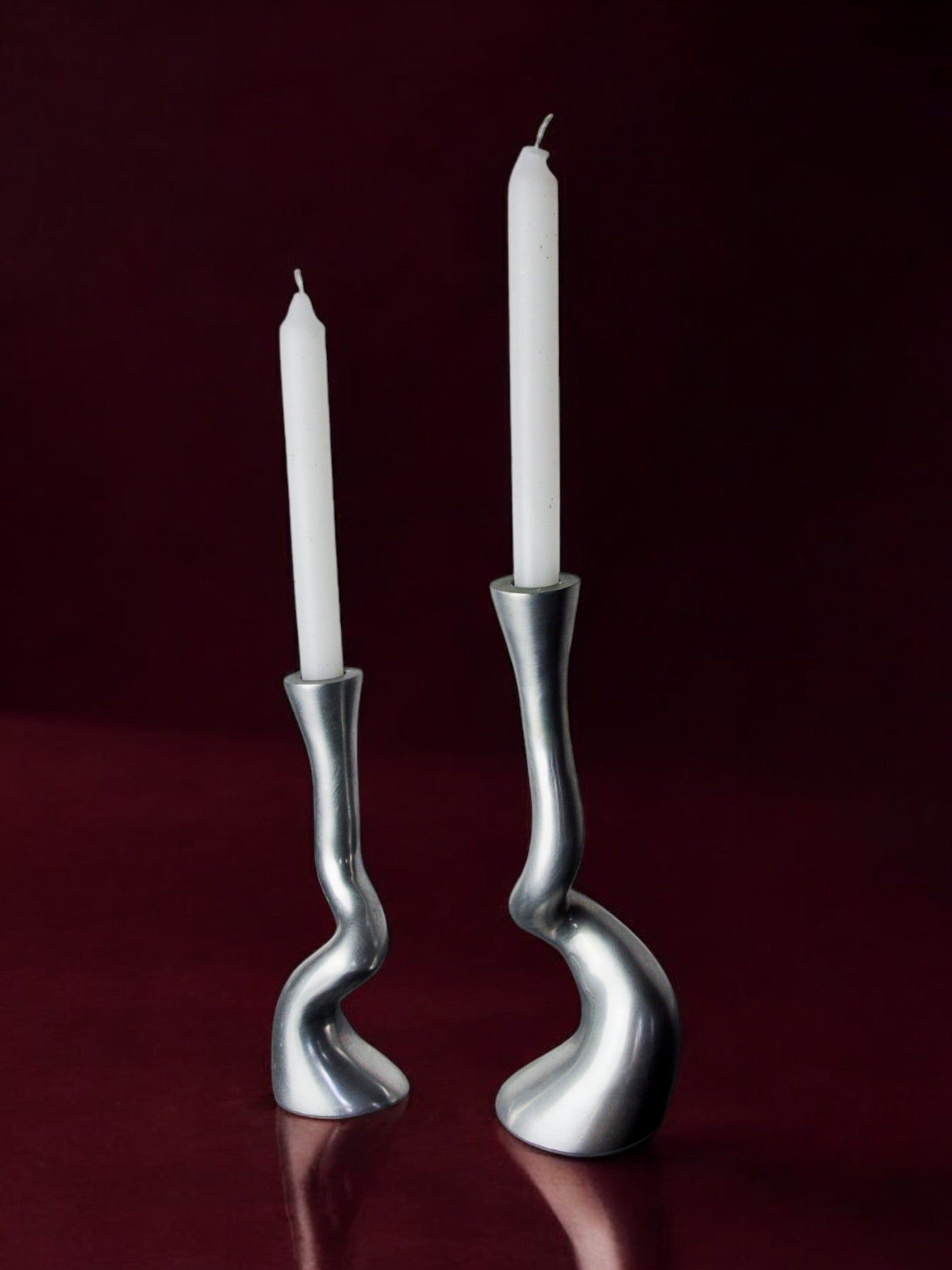 Pair of Brutalist candleholders 1970s — side angle on burgundy background