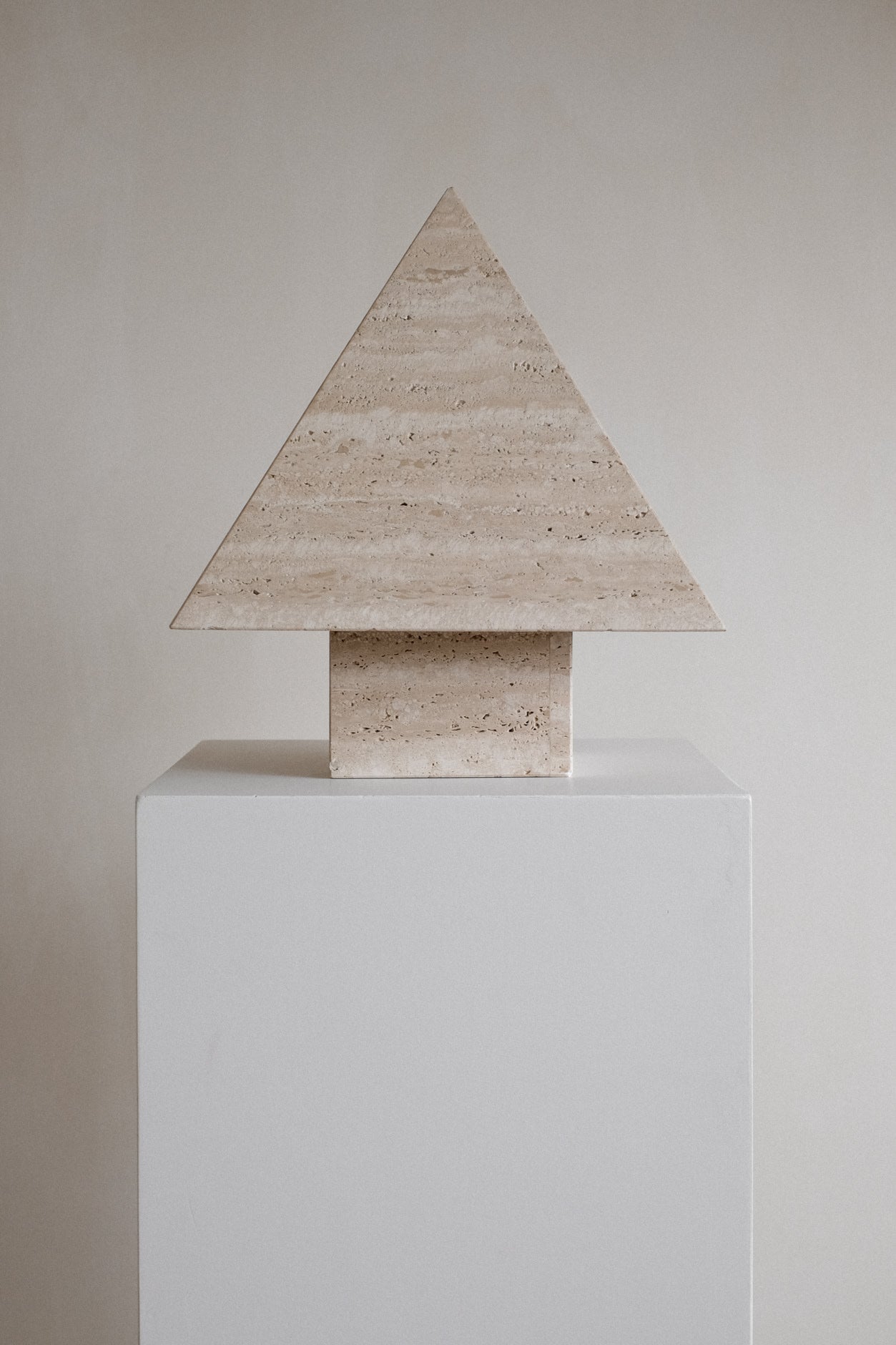 Travertine Pyramid Table Lamp — back view on white pedestal