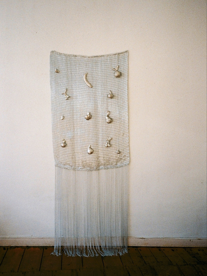 Handwoven wall sculpture with embroidered fruits and long fringe