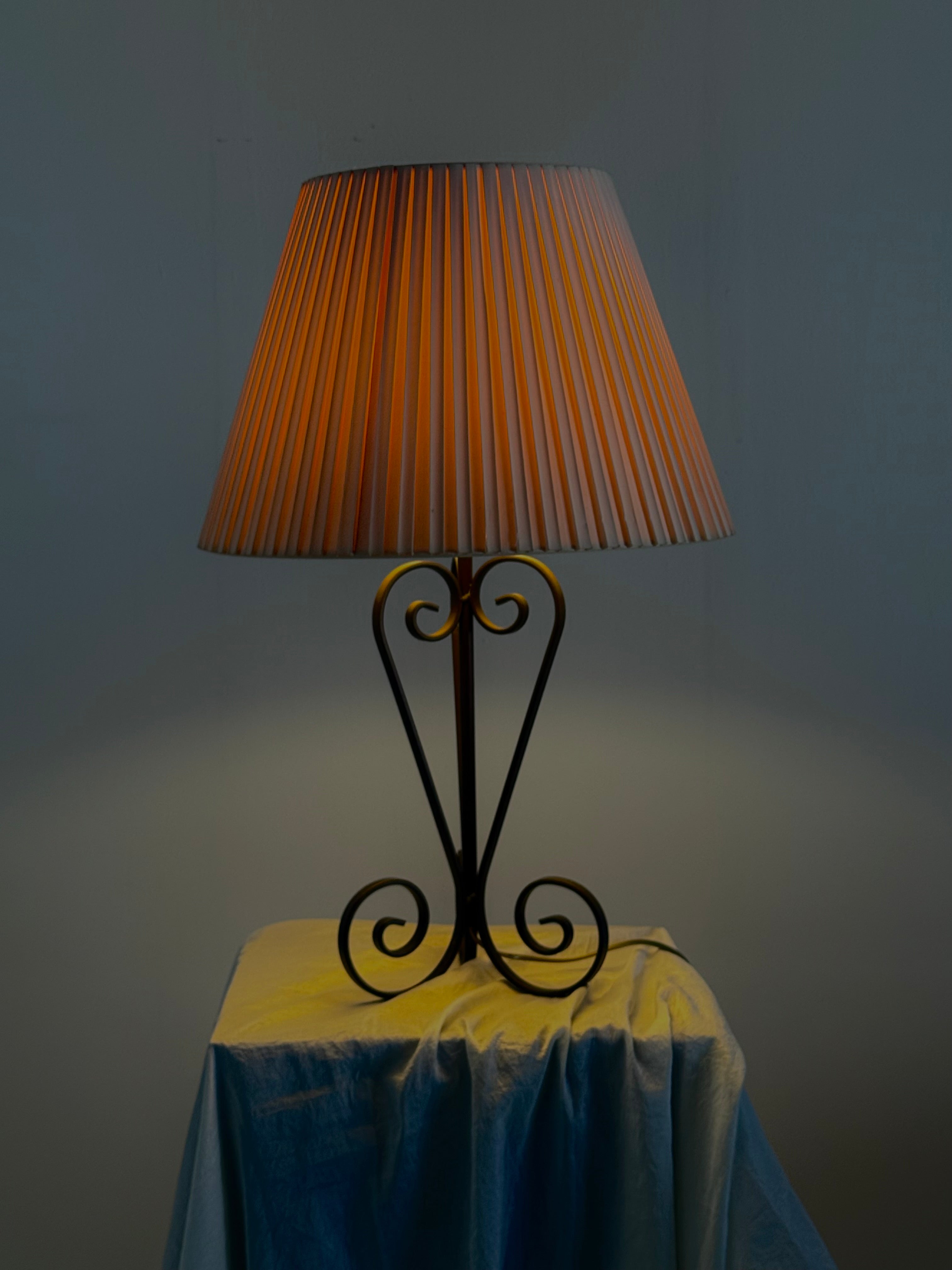 Vintage wrought iron table lamp in a swirl shape with a pleated shade — side angle