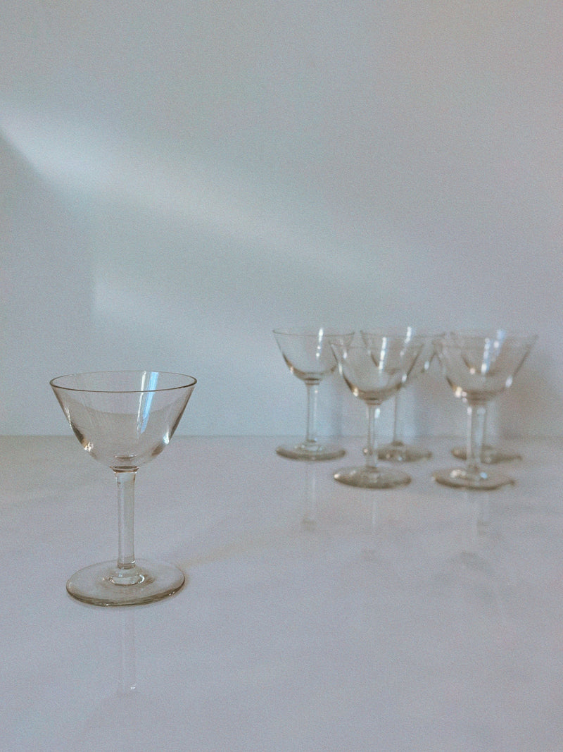 Swedish crystal cocktail glasses arranged on white surface with soft lighting