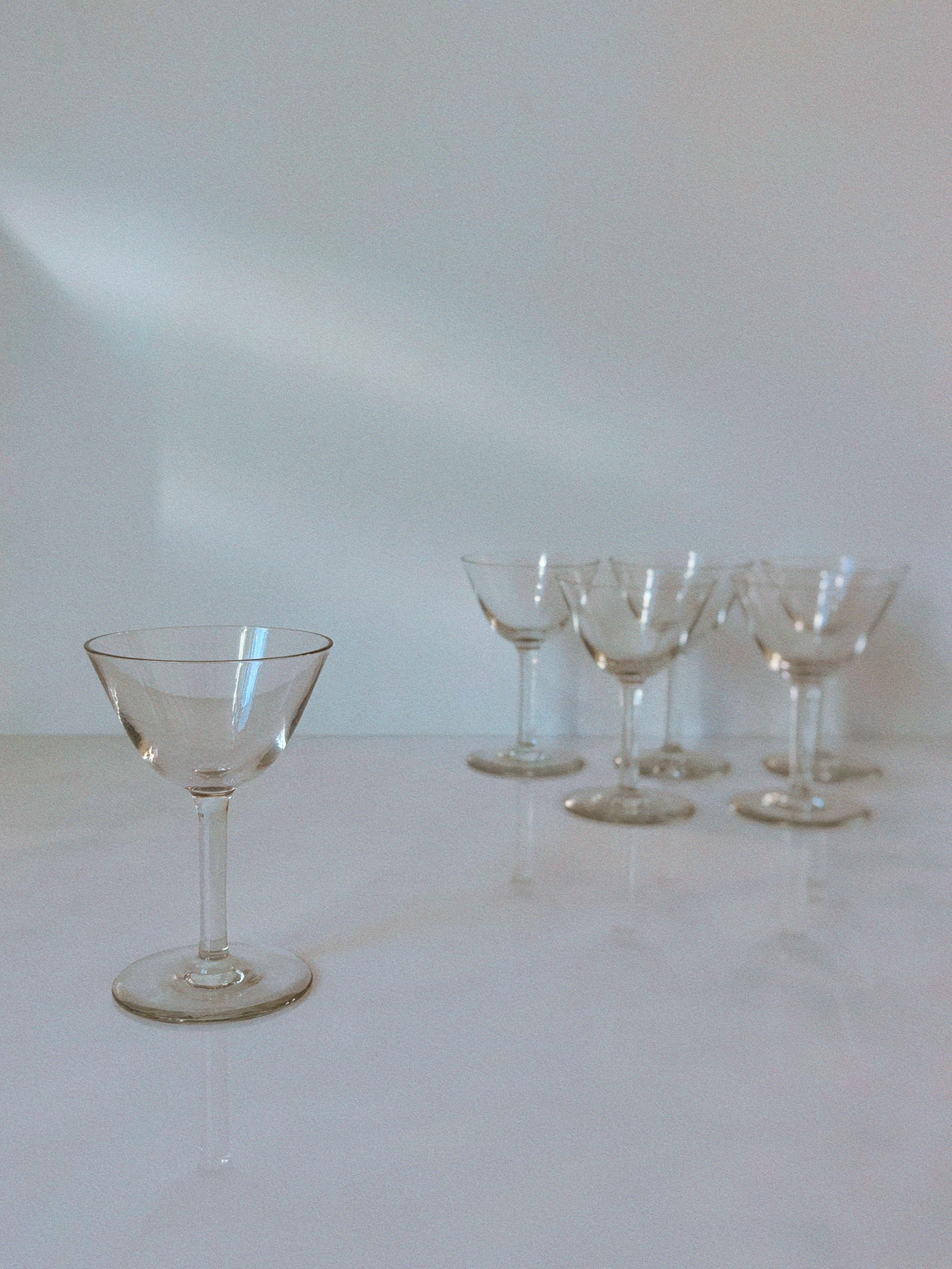 Swedish crystal cocktail glasses arranged on white surface with soft lighting