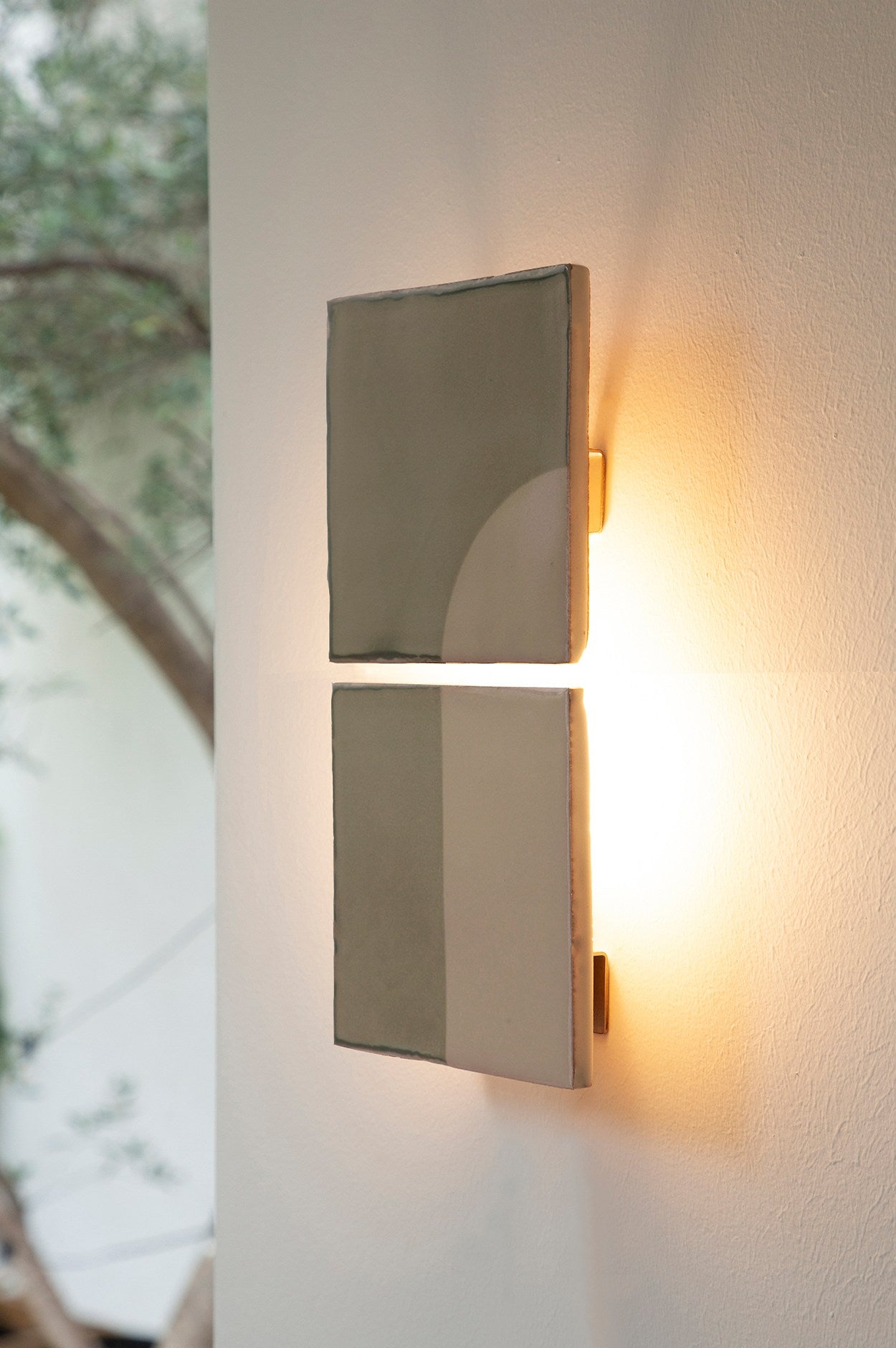 Modern concrete wall lamp with geometric cutouts creating warm ambient lighting