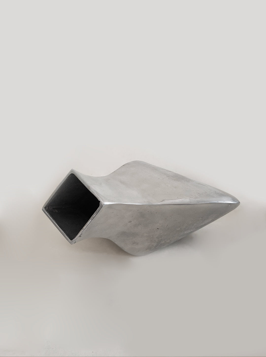 Sculptural Chrome Vase — angled view highlighting reflective surface