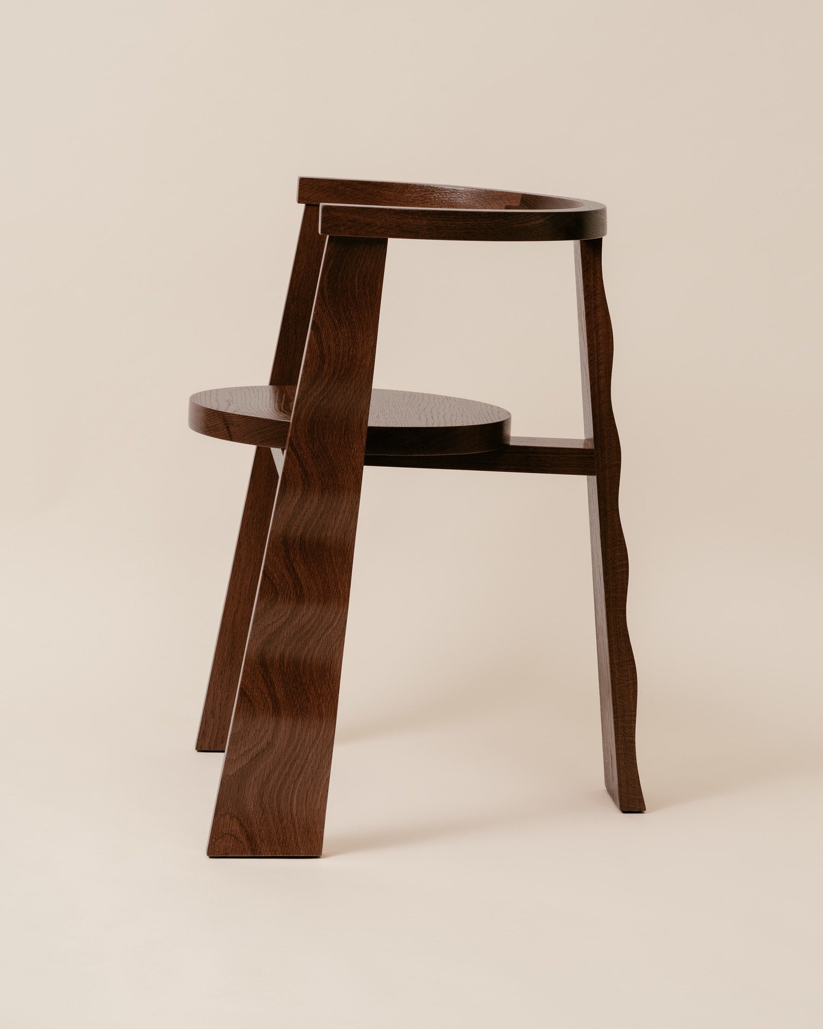 Puro walnut chair angled view showing curved legs and circular seat