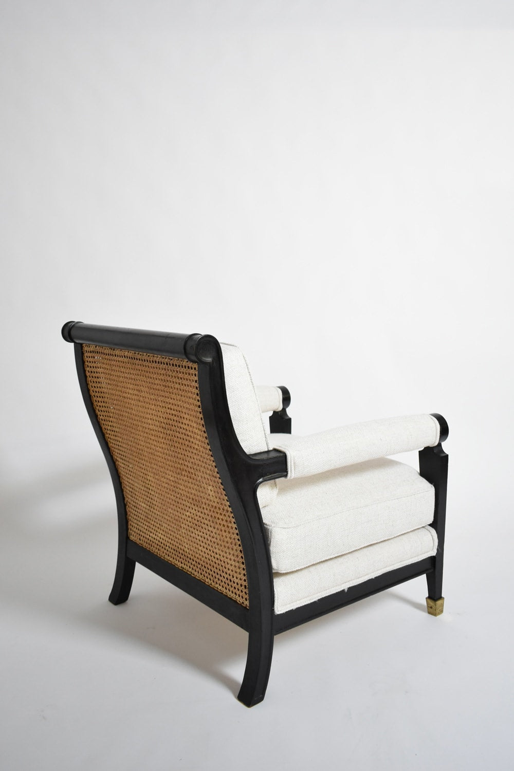 Pair of neoclassical ebonised wood and caning armchairs, 1960s — side angle showing caned backrest and upholstered seat