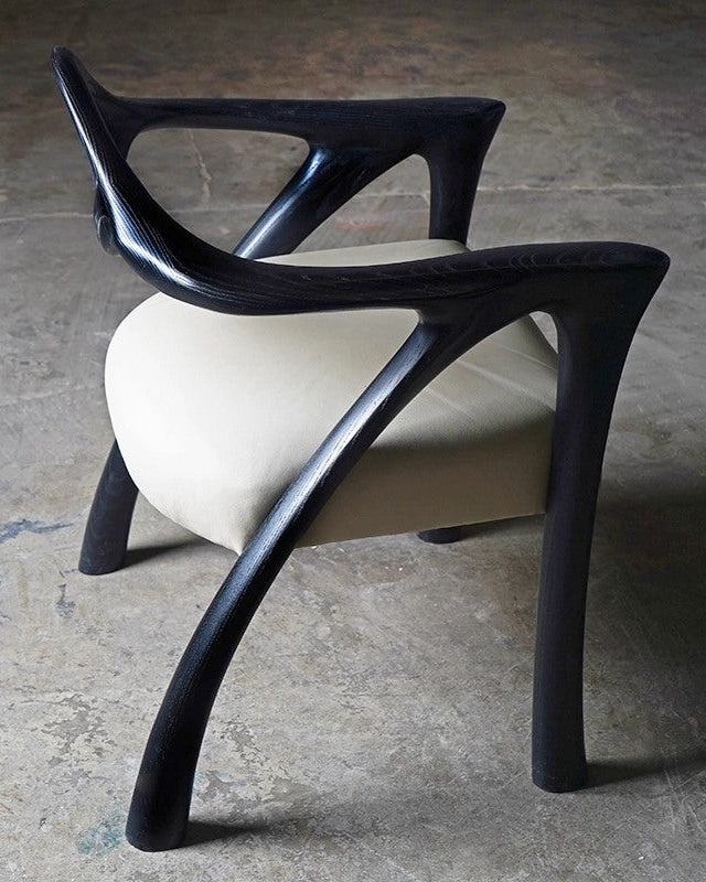 Darcey Armchair in Ash wood by Amorph — close-up of curved black wooden legs