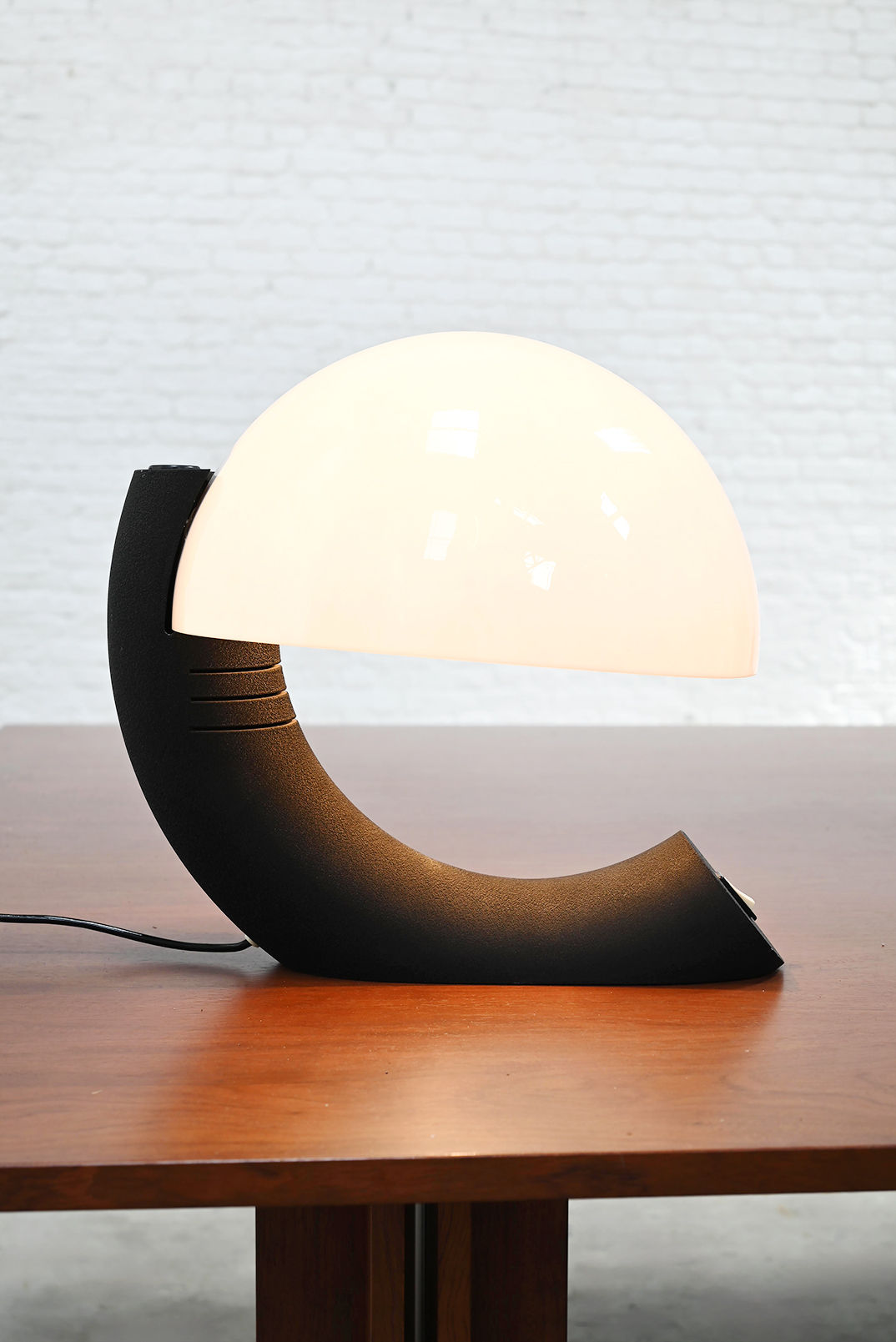 Italian Concordia table lamp with curved black base and glowing orb
