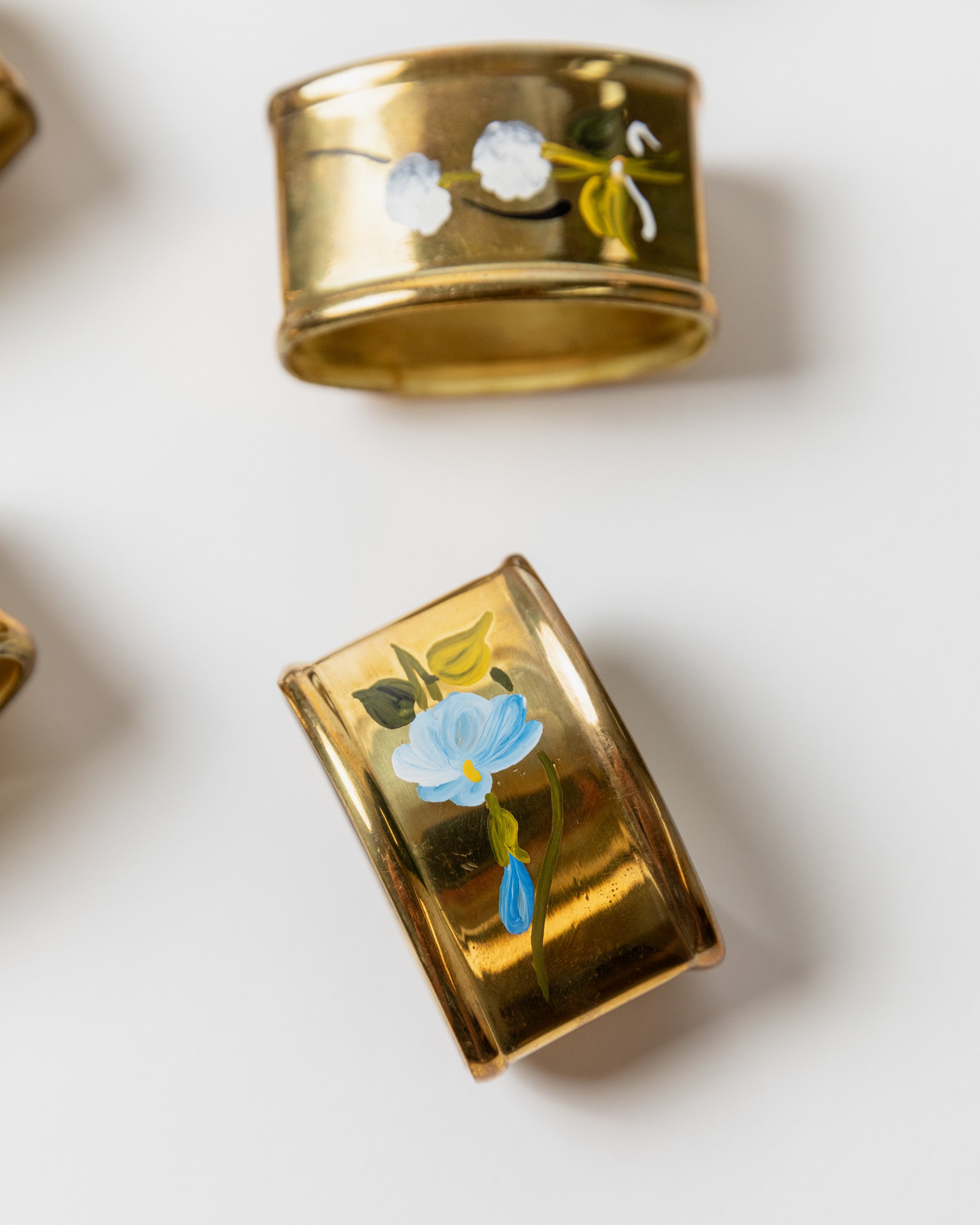 Close-up detail of hand-painted floral brass napkin rings Italy