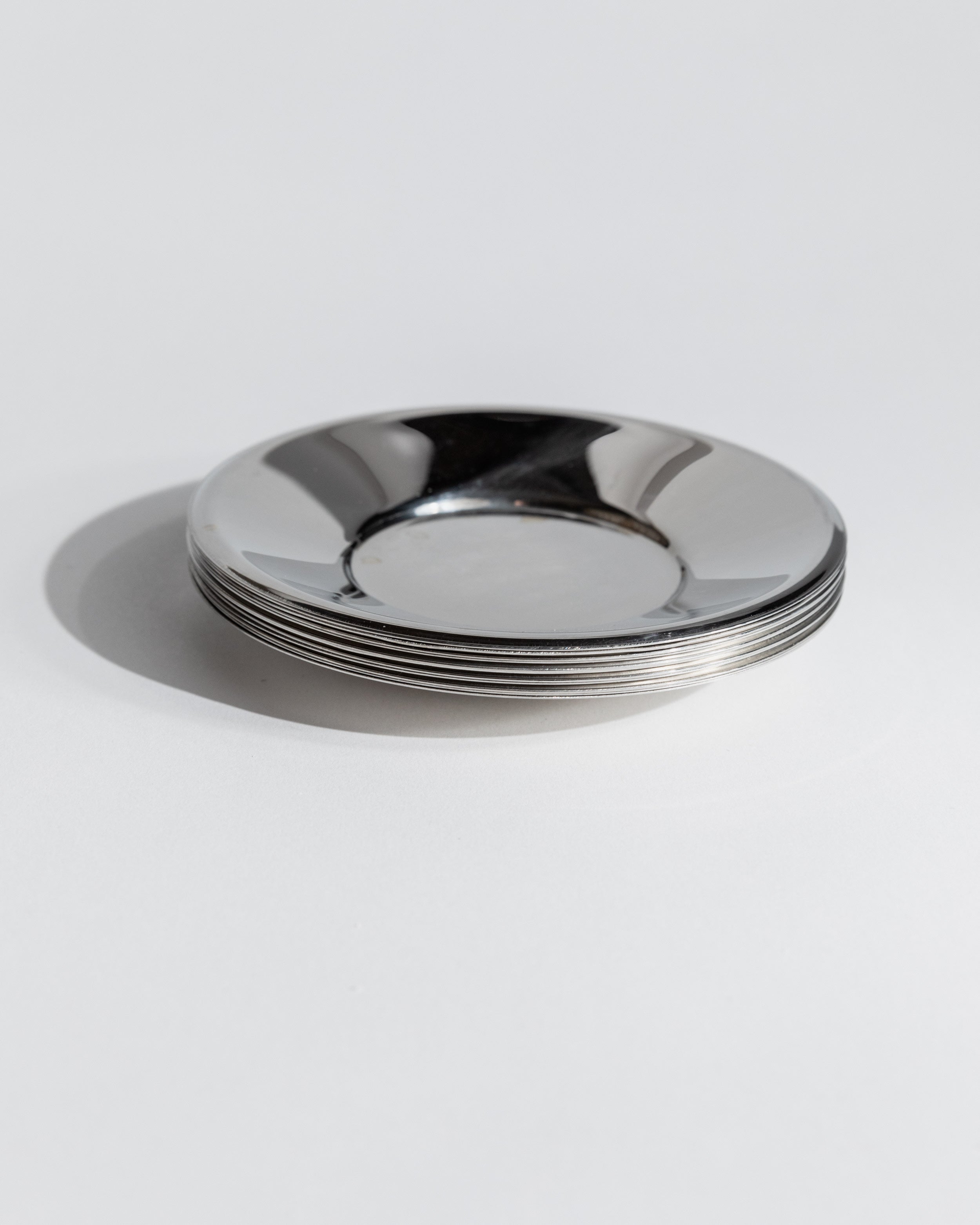 Stack of polished stainless steel saucers from 1980s coffee set