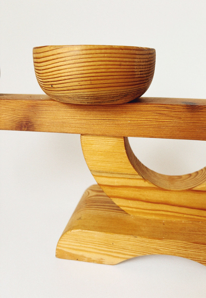 The Large Pine Candelabra by Stig Johnsson for Huerto features visible wood grain and a minimalist Nordic mid-century design, displayed on a curved stand with circular cut-out against a plain white background.