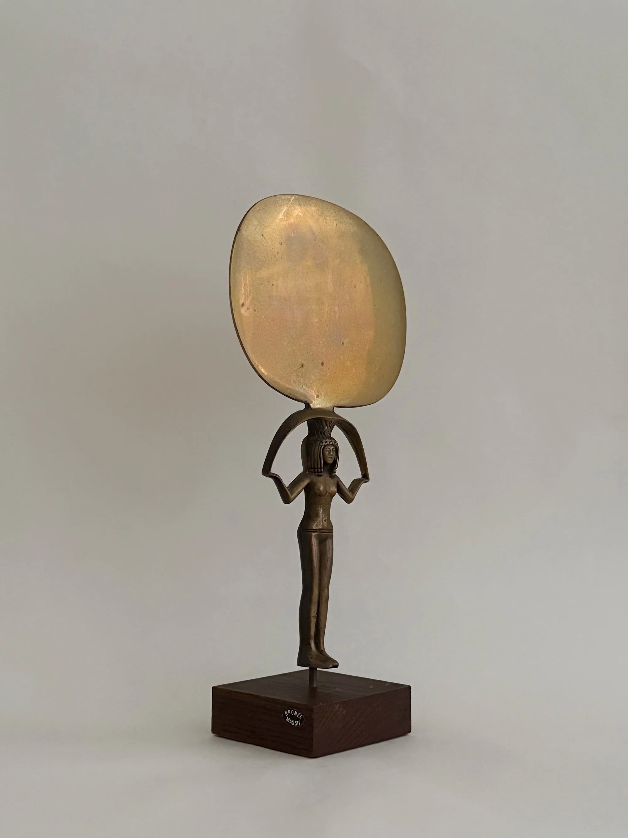 Bronze Sculpture of Isis Holding a Mirror — side angle showing polished surface and wooden base