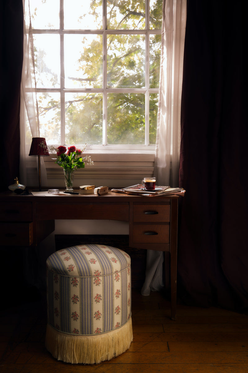 POMONA POEF - SOFA STRIPE 1 — styled beside wooden desk in natural light