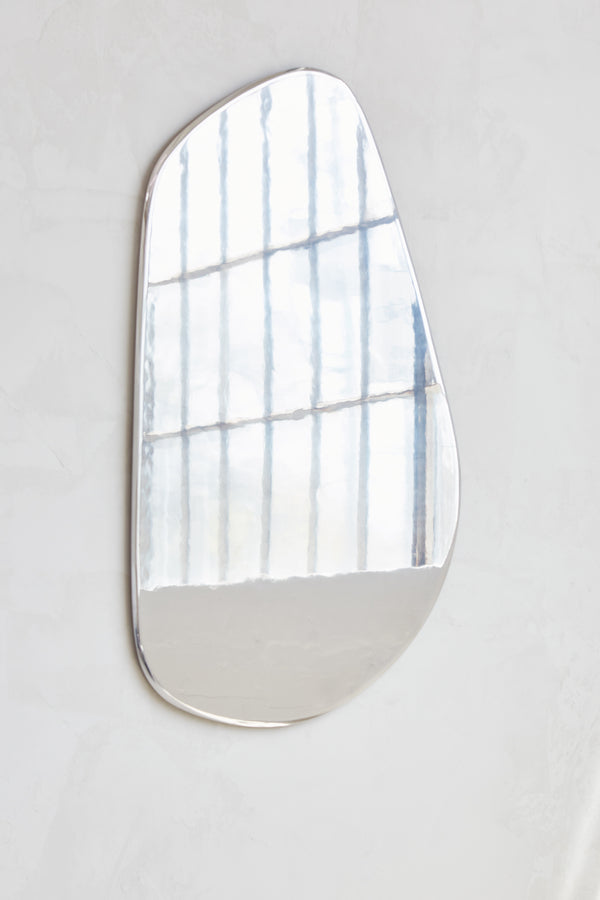 Geo Mirror in Polished Aluminum — top view reflecting light on wall