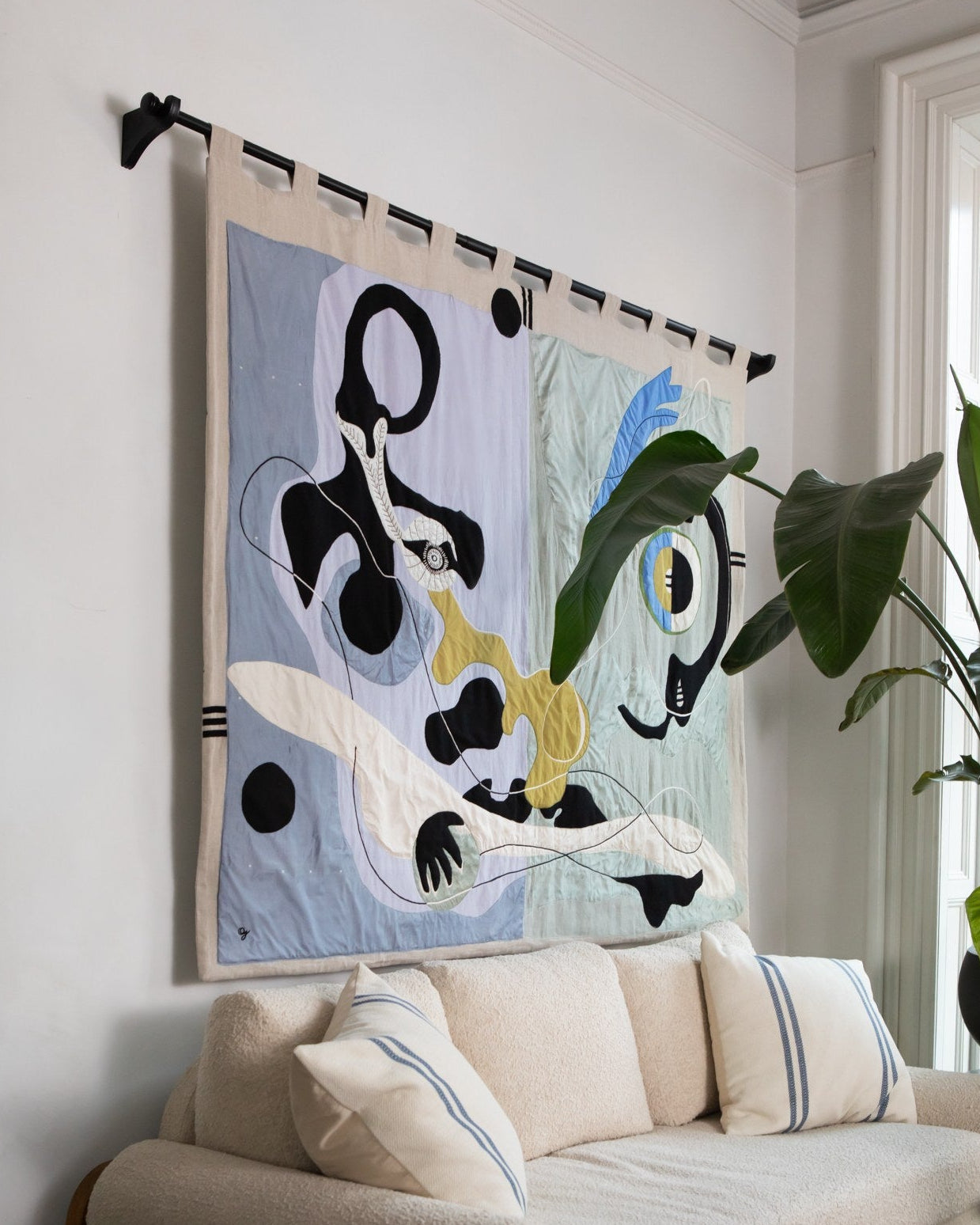 Languid Parts Tapestry — hung on wall above light-colored sofa