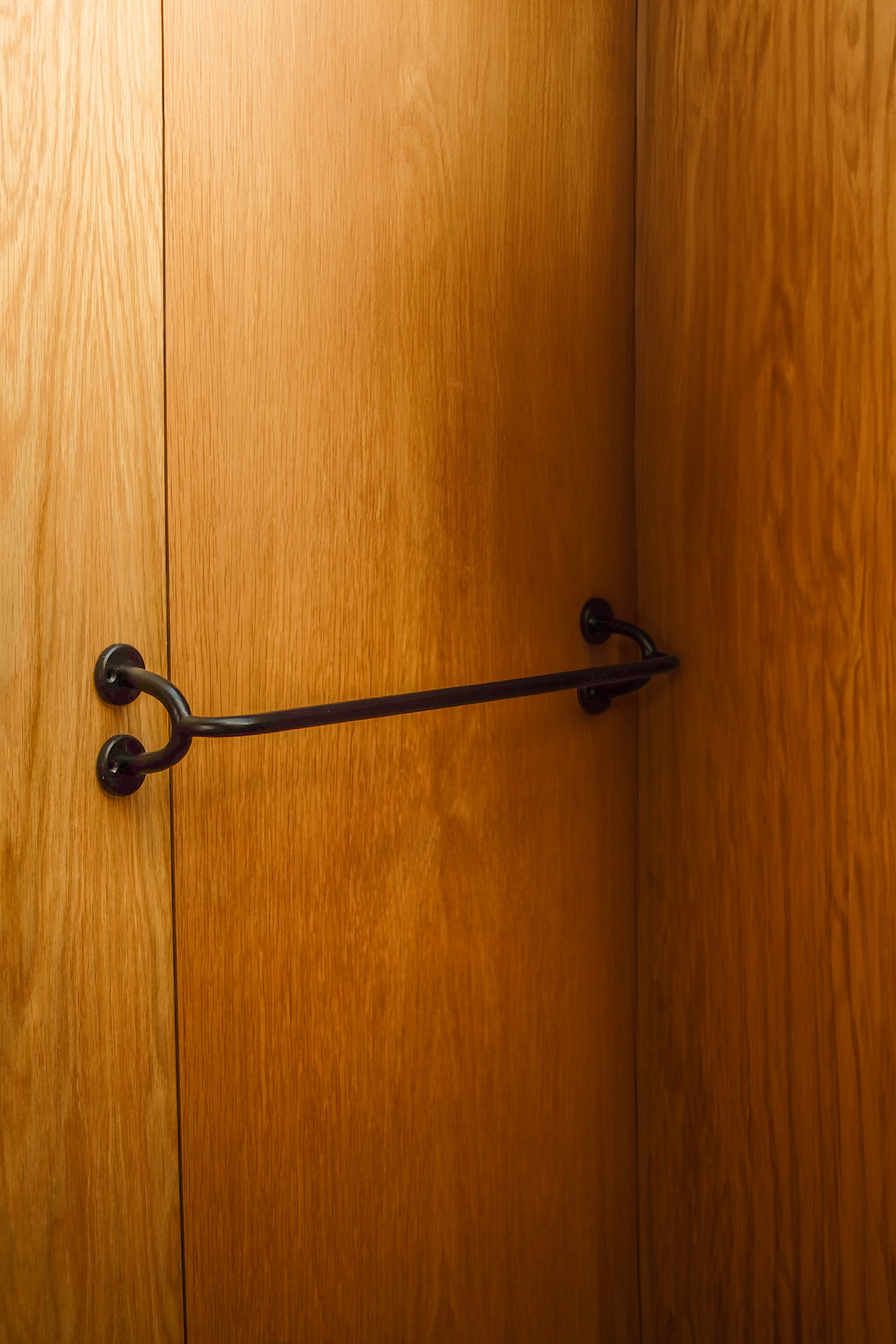 FAUNA Towel Bar (2 sizes) — close-up of black metal against wood paneling