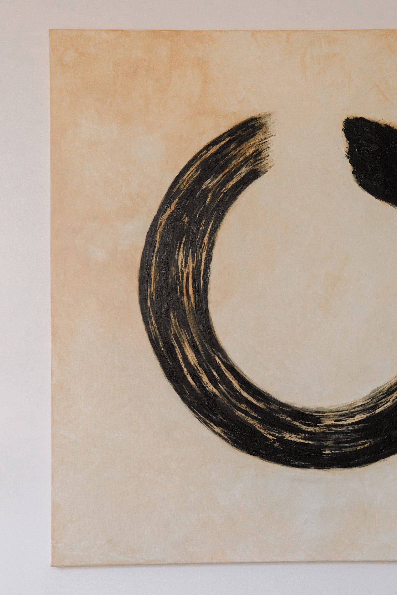 Ensō Acrylic on Linen by Inga Dzintare features a minimalist black brushstroke arc—suggestive of an incomplete circle—on a tan linen canvas, with the left edge visible for a striking, abstract composition.