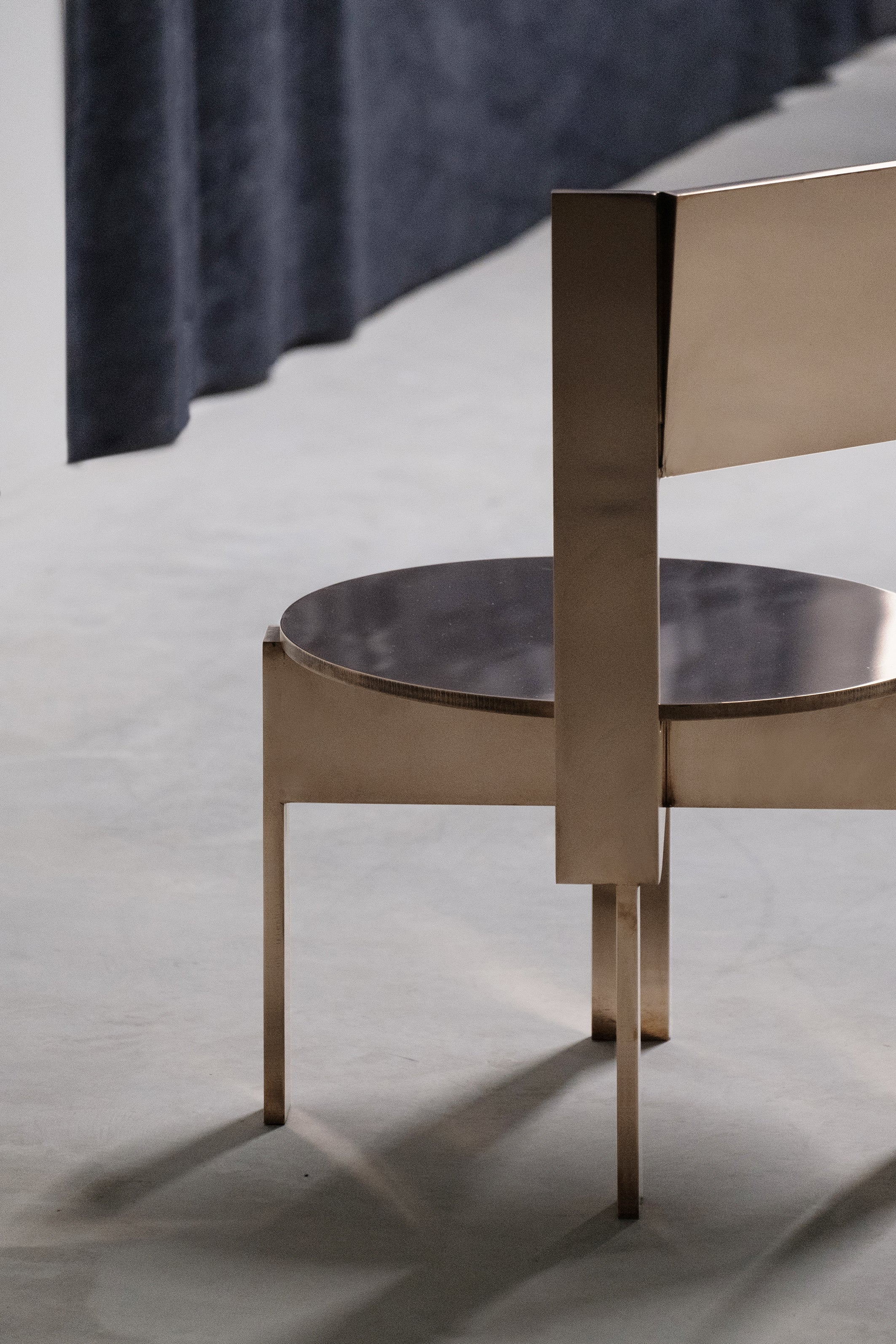 Ch 19.1 [b] - Low Chair — angled view of brass chair in studio setting