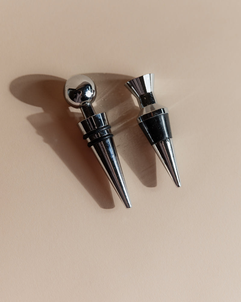 Vintage 1980s Bottle Stoppers Set of 2, Metal Geometric Conical Design Italy — close-up of polished metal surfaces on neutral