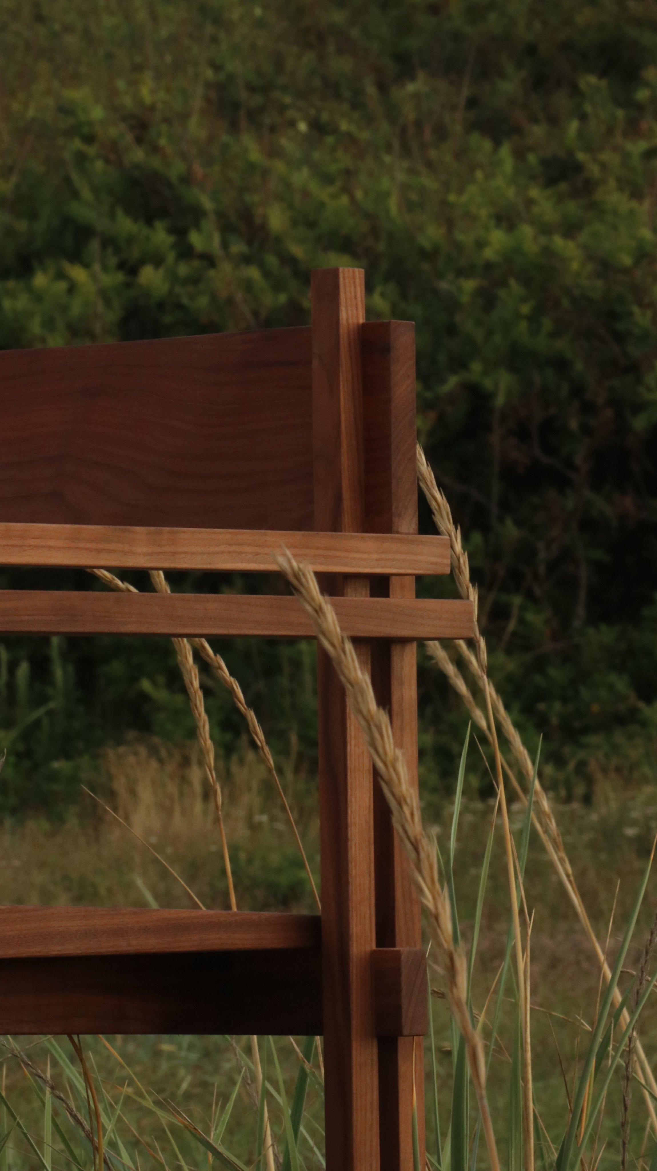 Stack chair with armrests — close-up of wooden frame in grass
