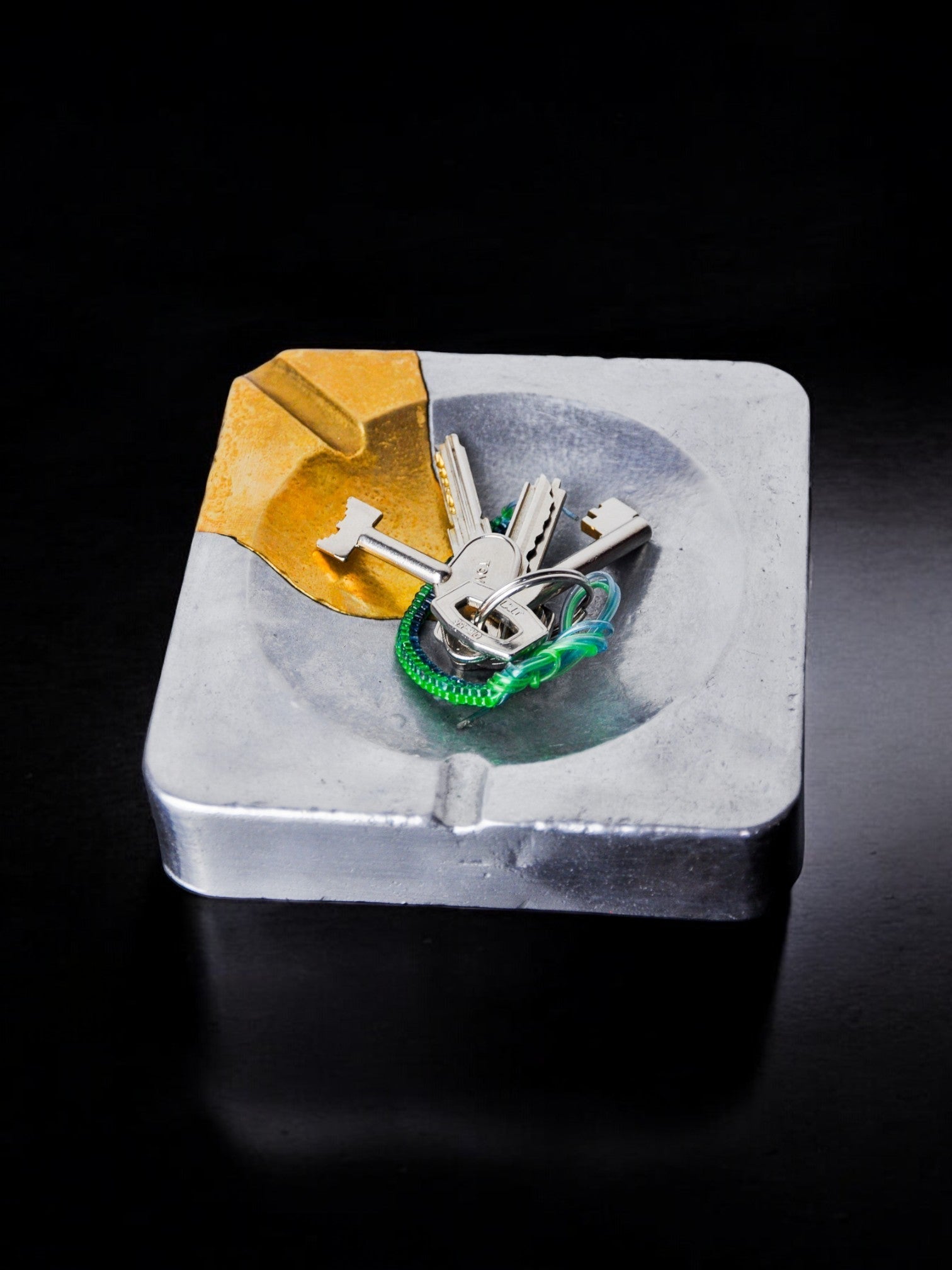 Brutalist ashtray by Art3, brass and aluminum, Spain, 1970 — side angle with keys on aluminum base